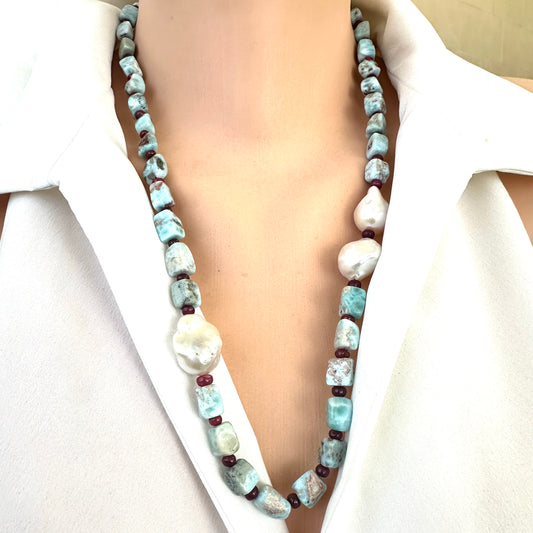 Detailed front view of larimar ruby and baroque pearl necklace showing blue and red gemstones