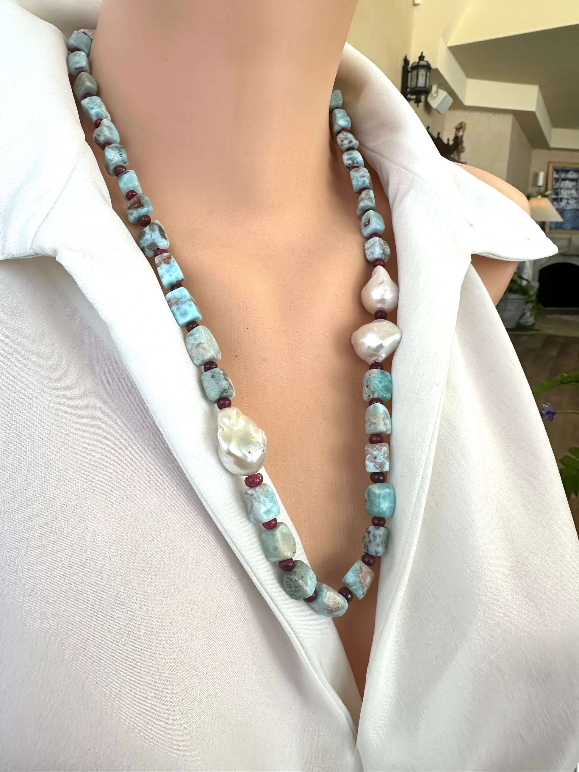Handmade larimar ruby and baroque pearl necklace on mannequin side view, silver clasp visible