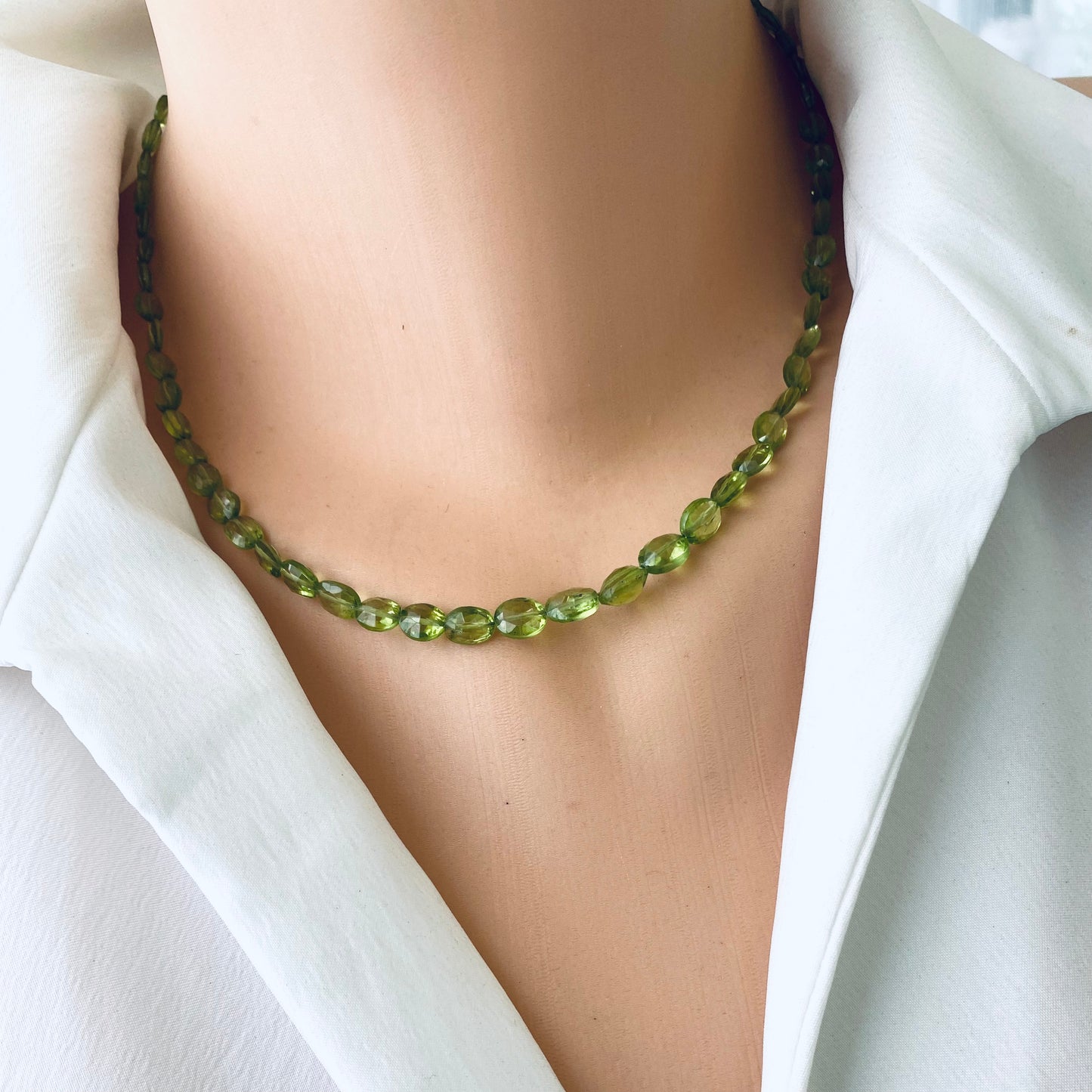 Peridot necklace 14K gold filled displayed on a mannequin wearing a white shirt, showcasing its natural green brilliance.