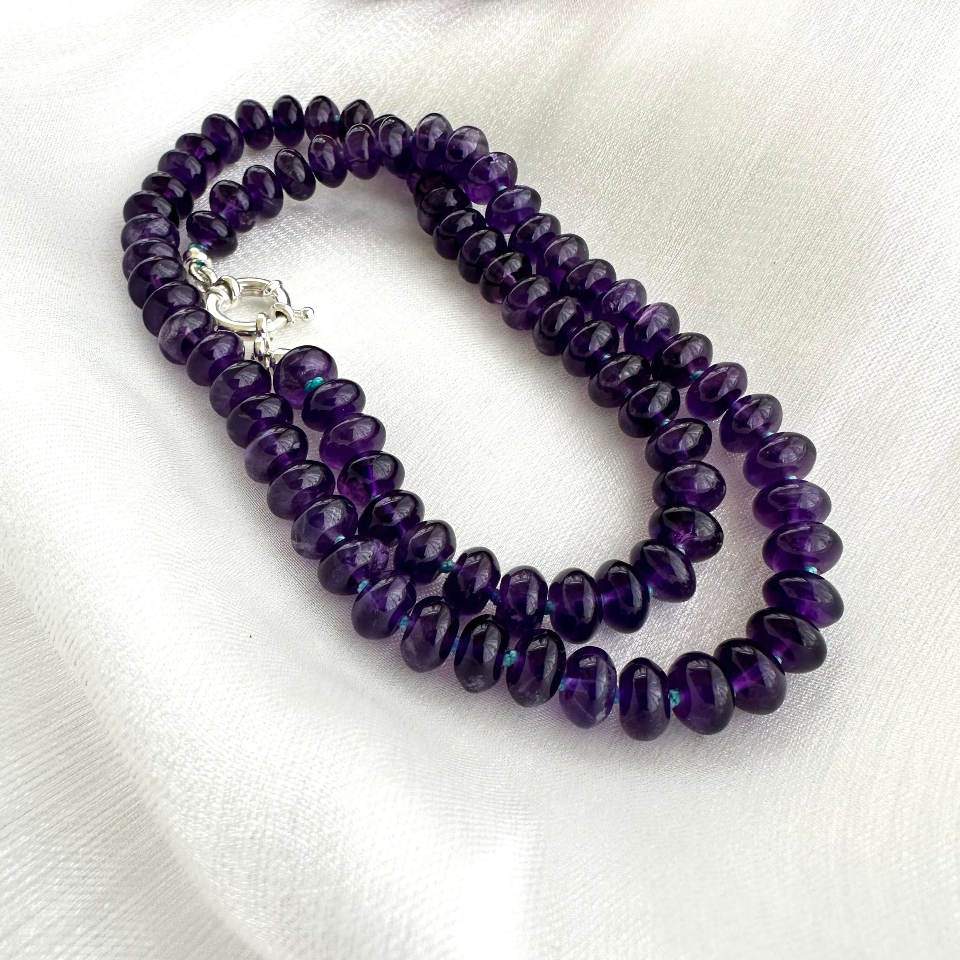 Amethyst beaded necklace with sterling silver clasp displayed on white background