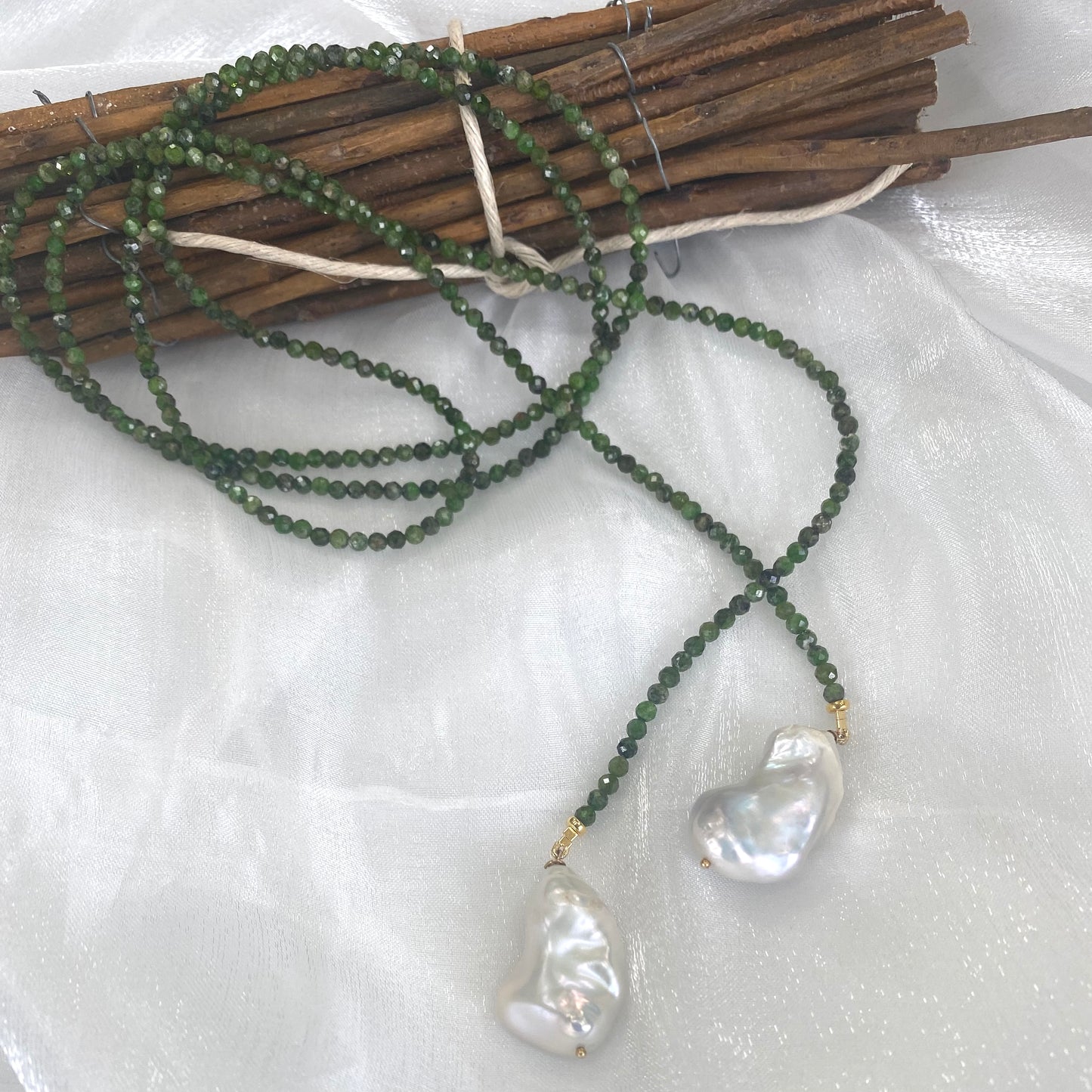 Green diopside lariat necklace with Baroque pearls, showcasing vibrant green beads and elegant design.