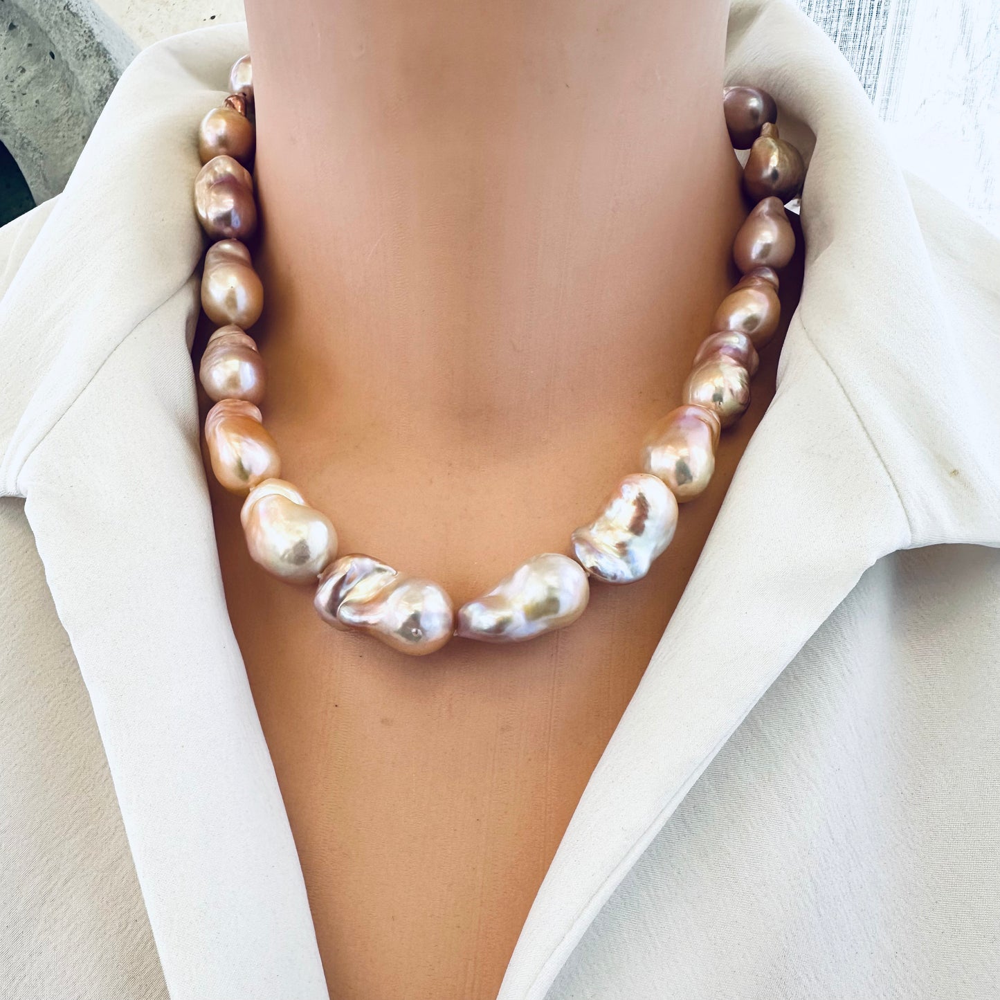 Golden pink baroque pearl necklace on mannequin, front view showing elegant clasp