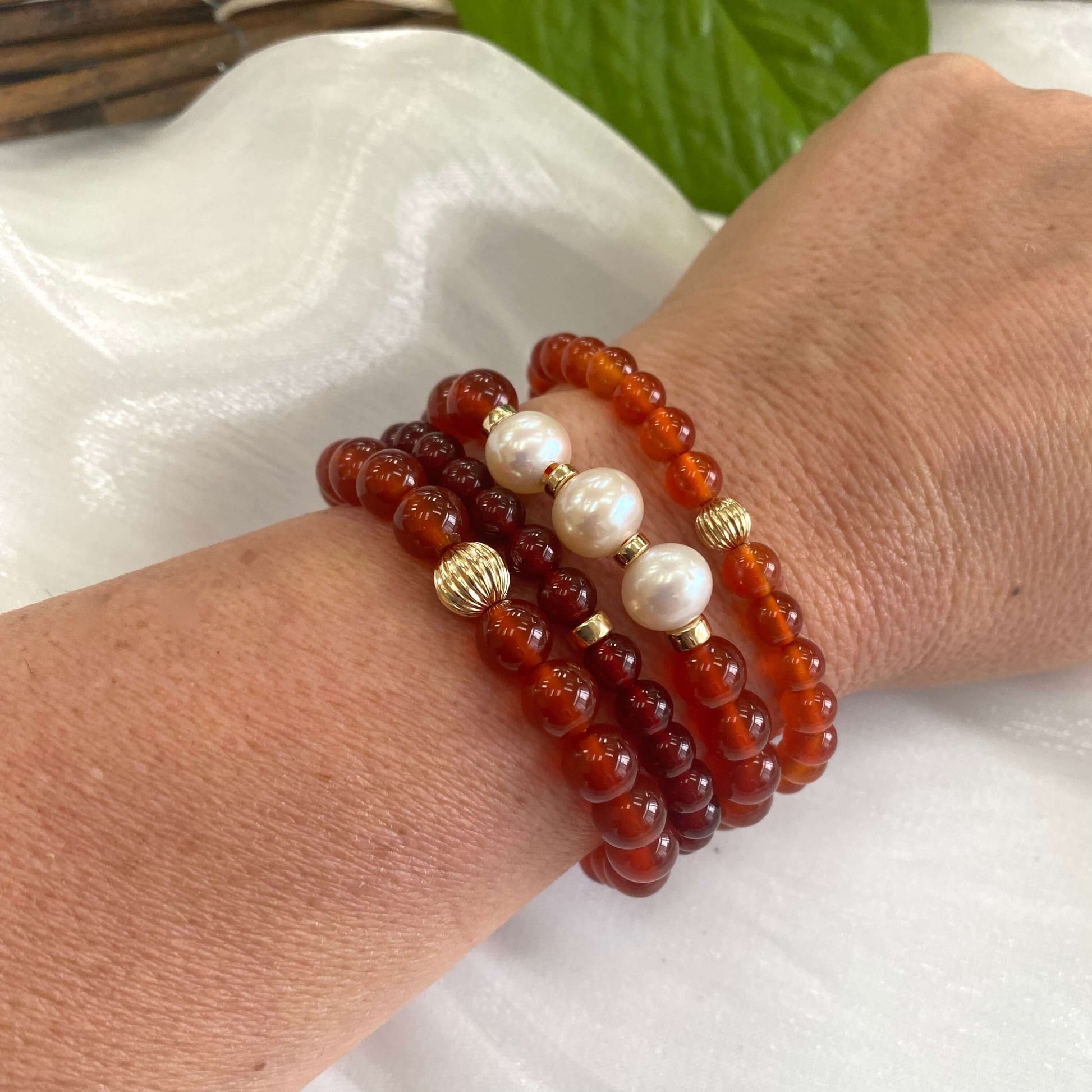 Orange Carnelian Bracelet worn with other bracelets on woman’s wrist – lifestyle shot