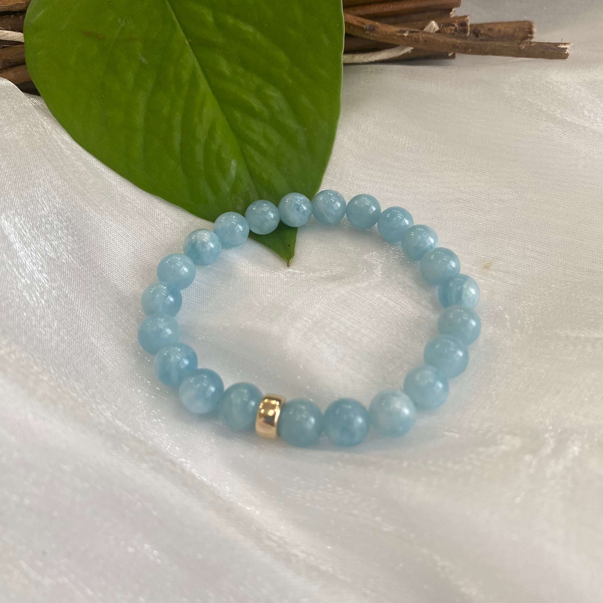 Aquamarine stretch bracelet made of 6mm beads with a 14K gold filled accent, featuring a calming ocean blue color.