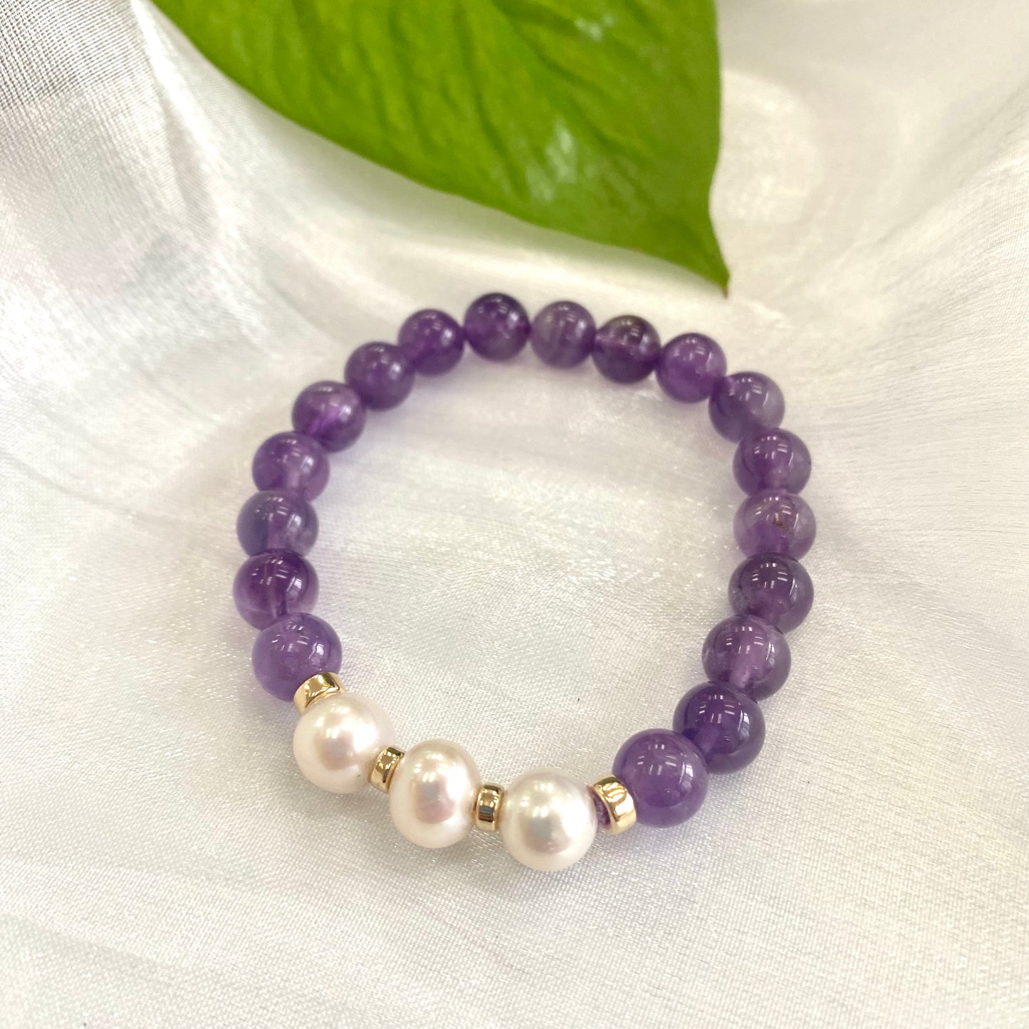 Amethyst Pearl Bracelet displayed on white cloth – single bracelet close-up with pearls