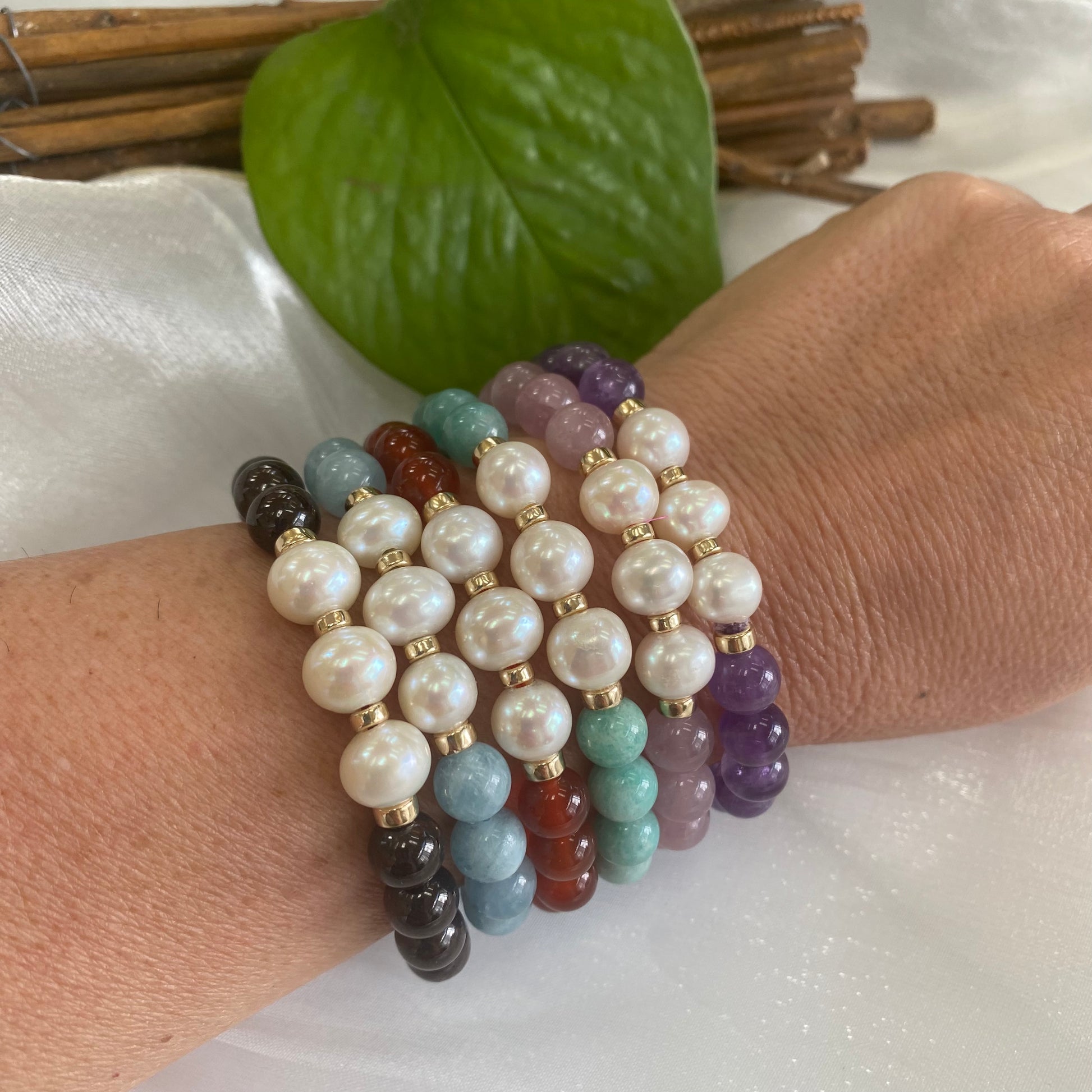 Amethyst Pearl Bracelet worn with other colourful bracelets on woman’s wrist – stacked look