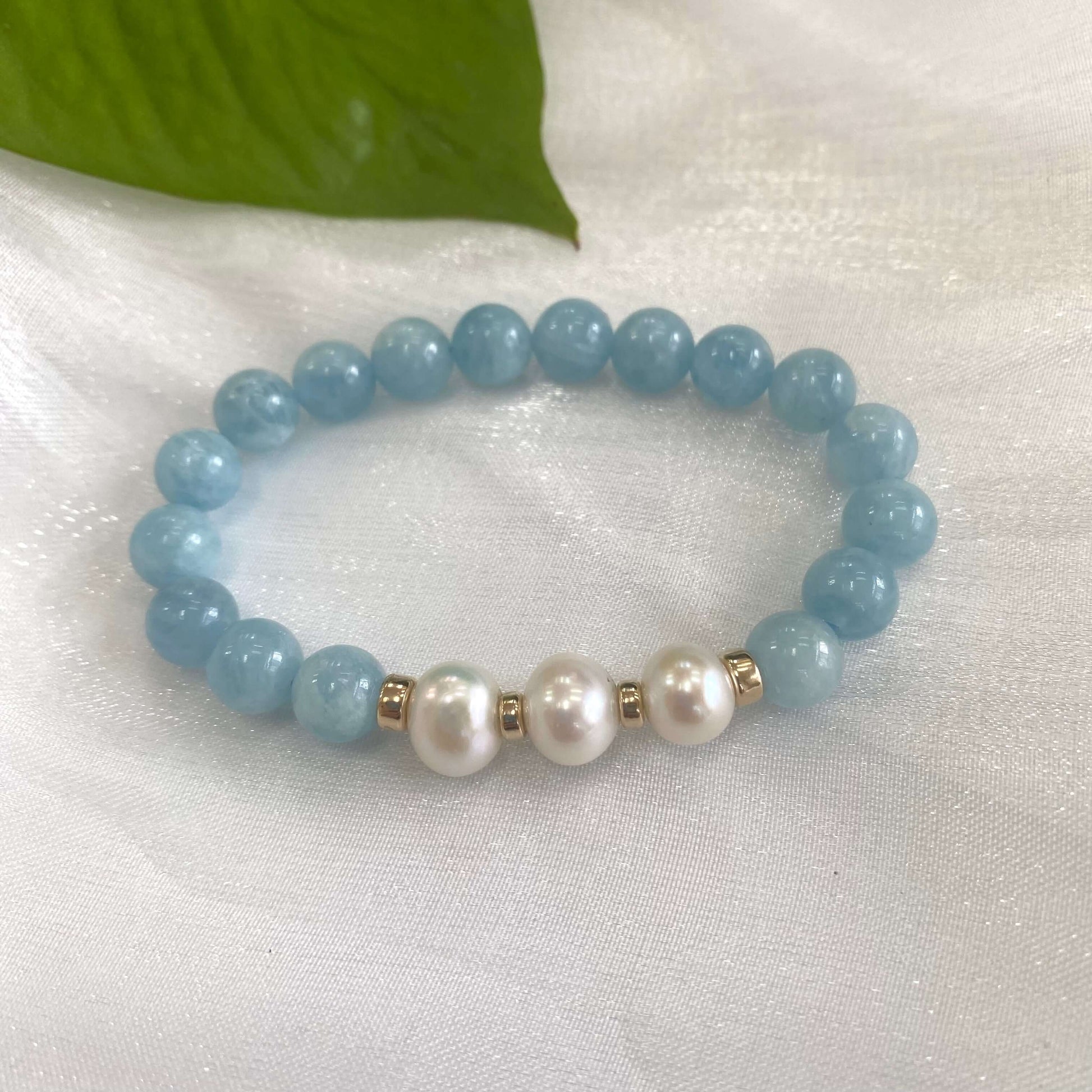 Aquamarine pearl bracelet featuring 8mm aquamarine beads and 9-10mm freshwater pearls with gold accents.