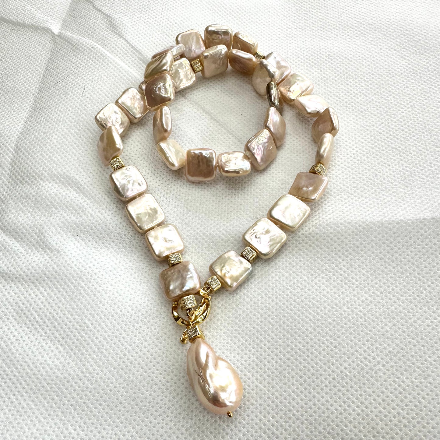 Full view of golden baroque pearl toggle necklace on white backdrop — handcrafted statement jewelry featuring square pearls and gold clasp