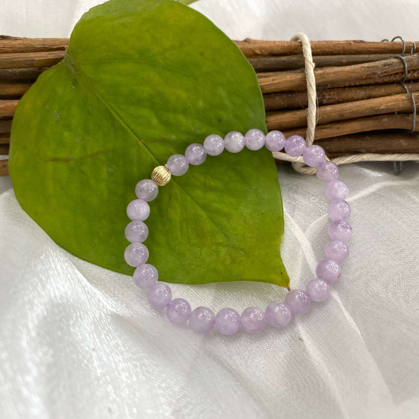 Lavender amethyst stretch bracelet – 6mm or 8mm, 14K gold filled on a green leaf backdrop.