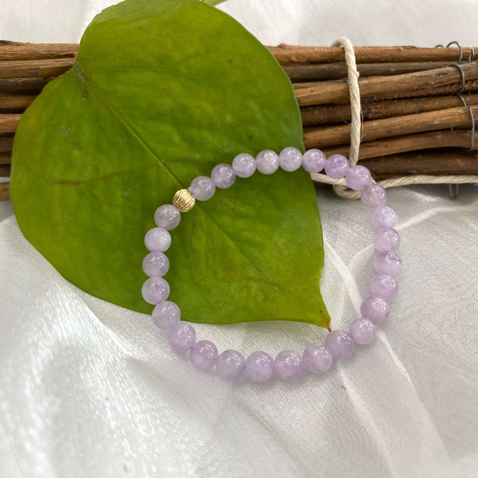 Lavender amethyst stretch bracelet – 6mm or 8mm, 14K gold filled on a green leaf backdrop.