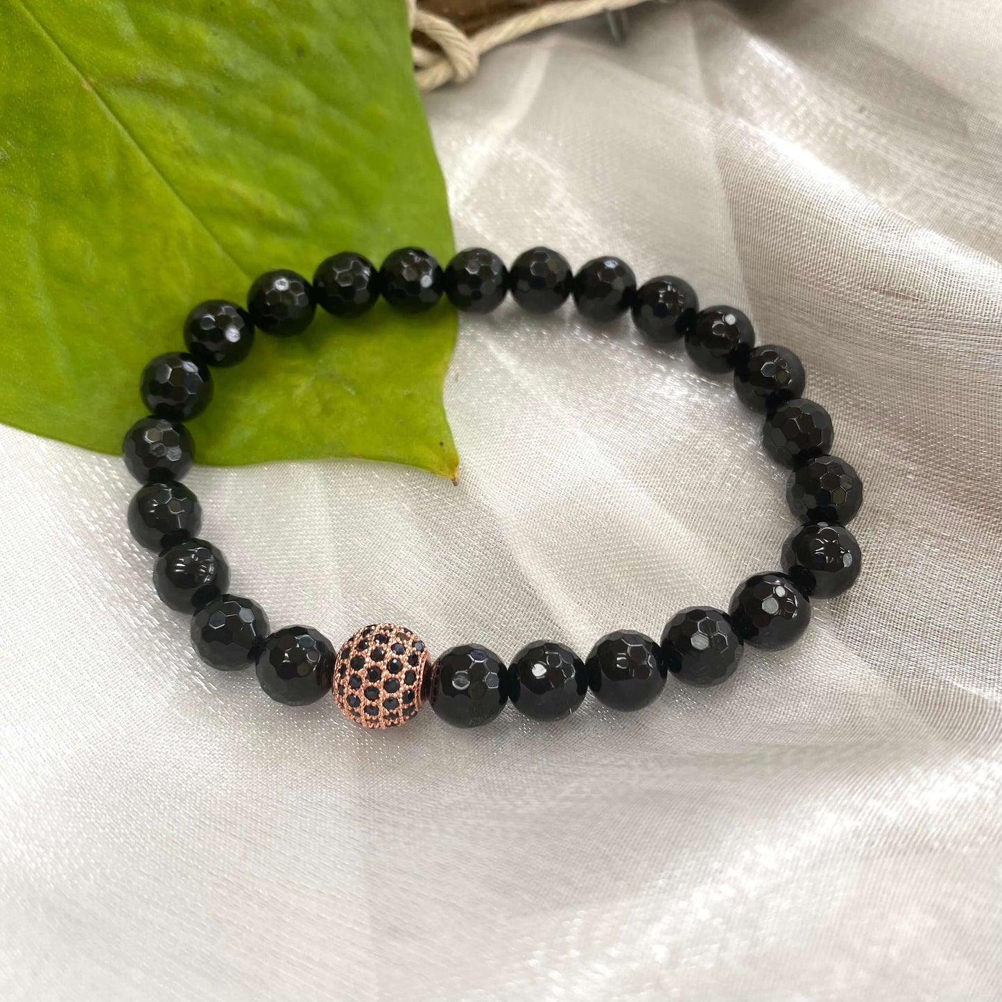 Black Onyx Mens Bracelet featuring stretch design and rose gold accents, handcrafted with 8mm faceted beads.