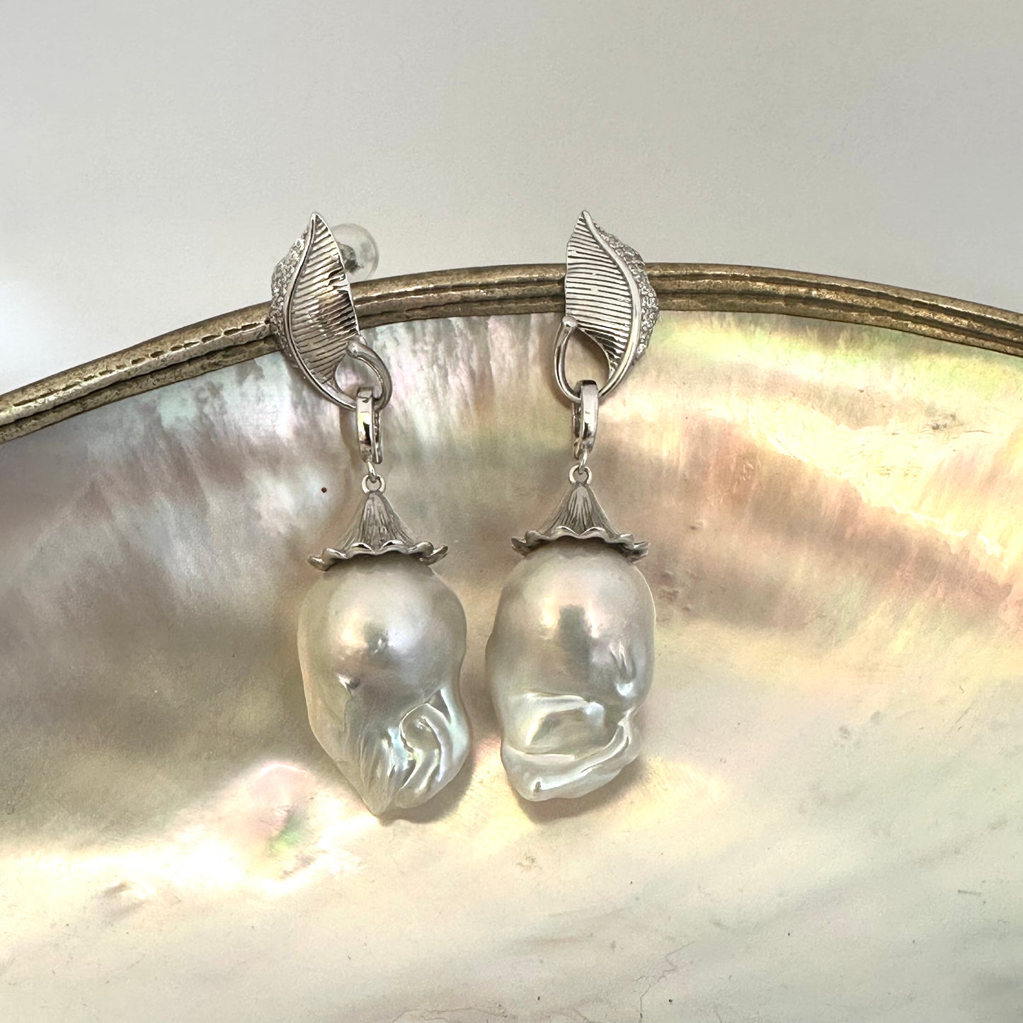 Detailed view of Leaf Design Baroque Pearl Earrings on white surface — polished sterling silver leaves and removable baroque pearls by Loulia Pearl Jewelry
