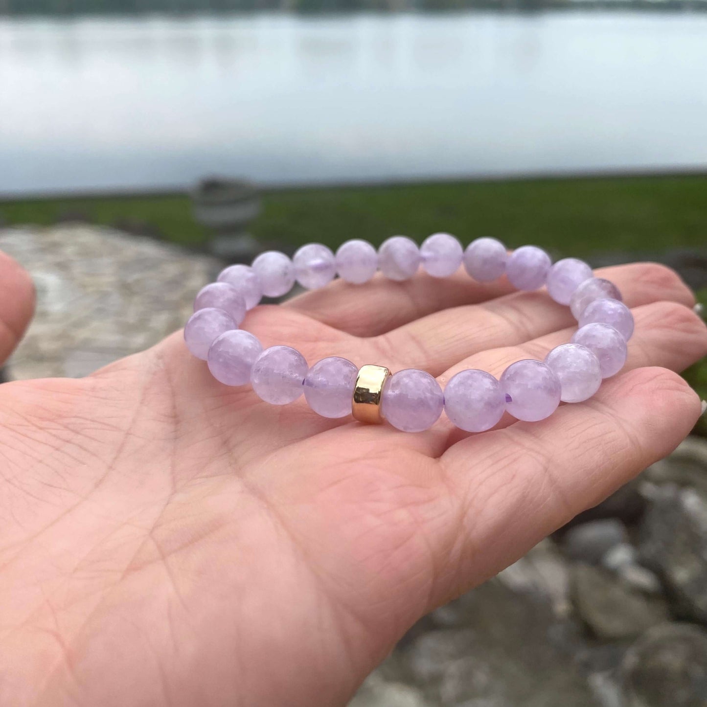 Lavender Amethyst Bracelet shown in hand with lake backdrop – natural light