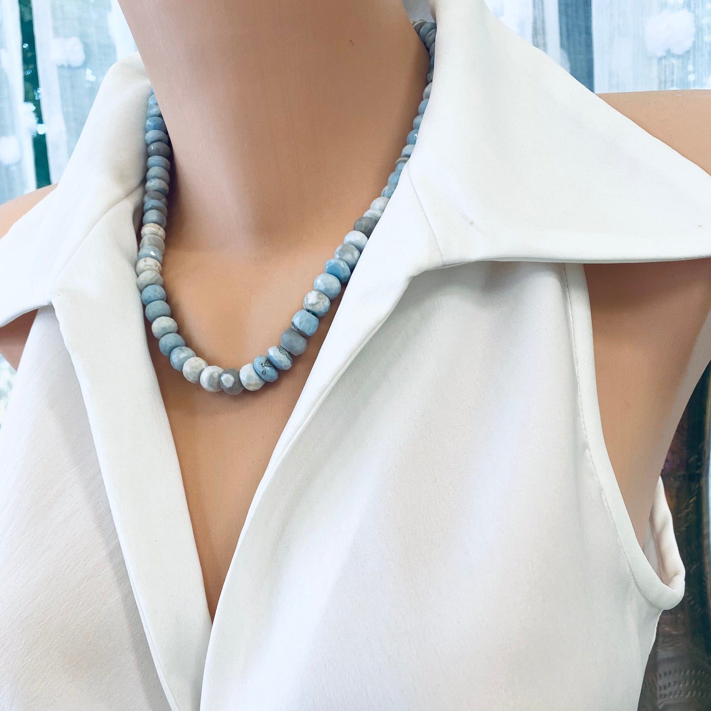 Side close-up of blue grey opal necklace on mannequin showing faceted candy design