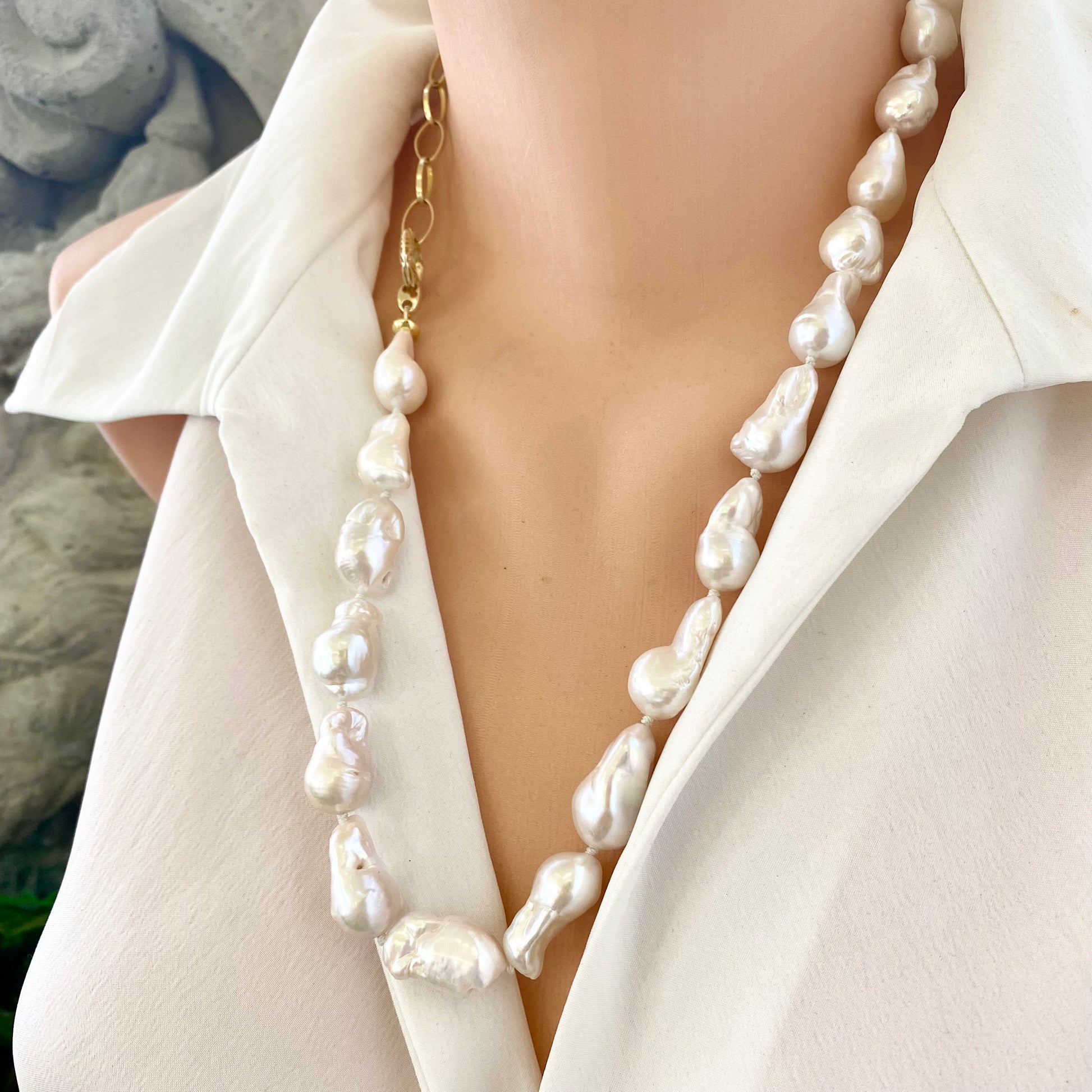 White baroque pearl and gold chain necklace shown on mannequin, asymmetric handmade jewelry crafted in Canada.
