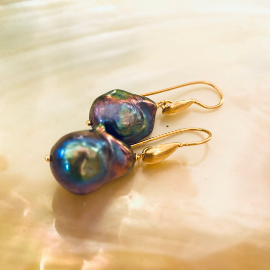 Handmade black baroque pearl drop earrings with gold vermeil hooks displayed on white pearl backdrop