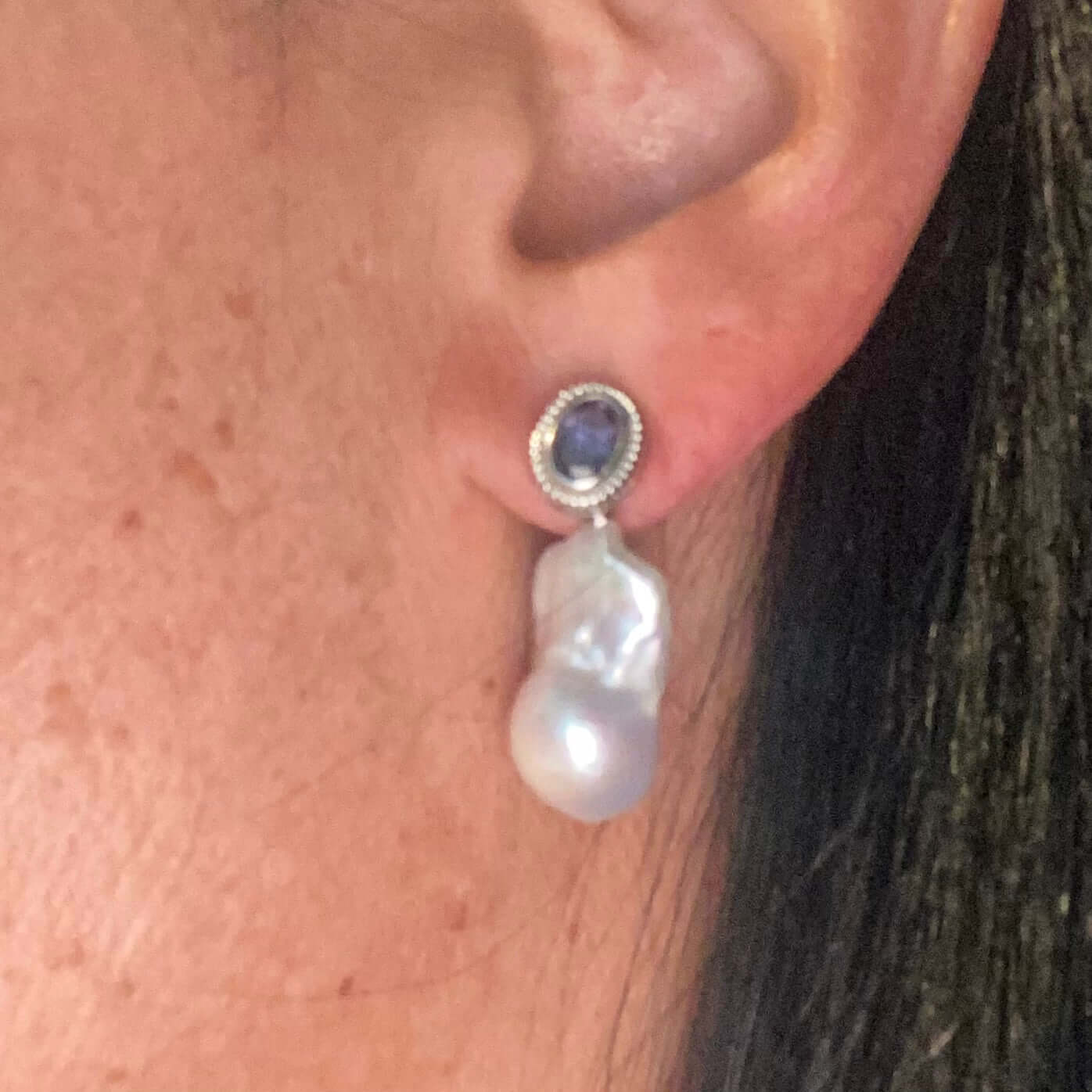 Iolite baroque pearl drop earrings worn on woman’s ear — handcrafted gemstone and pearl jewelry by Loulia Pearl Jewelry