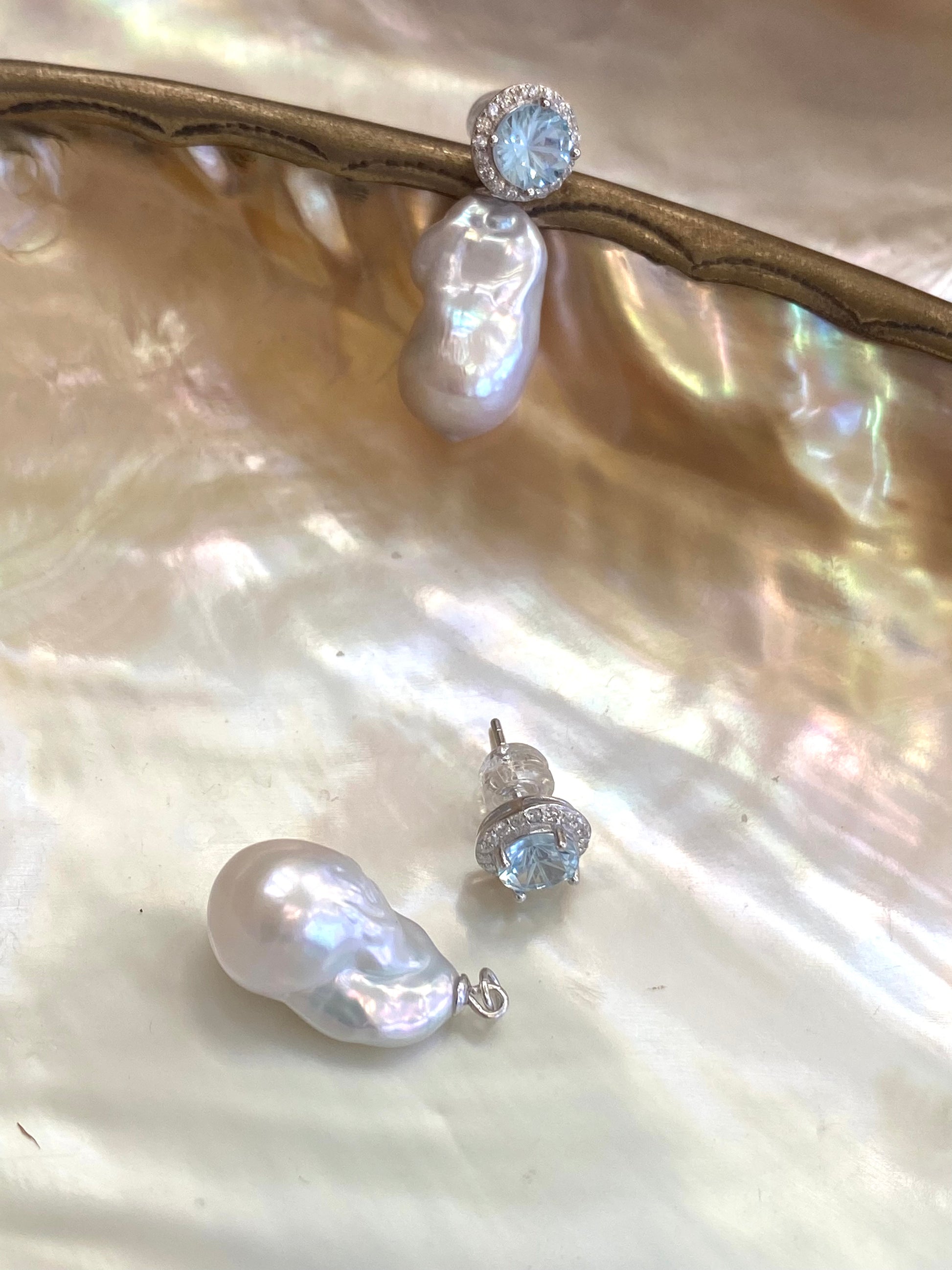 Convertible blue topaz pearl drop earrings with removable studs on shell background
