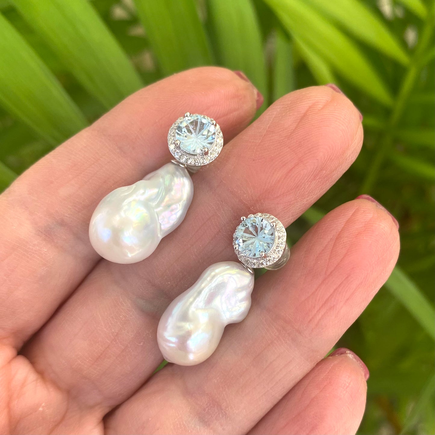 Blue topaz pearl drop earrings shown in hand for size reference, handmade in Canada