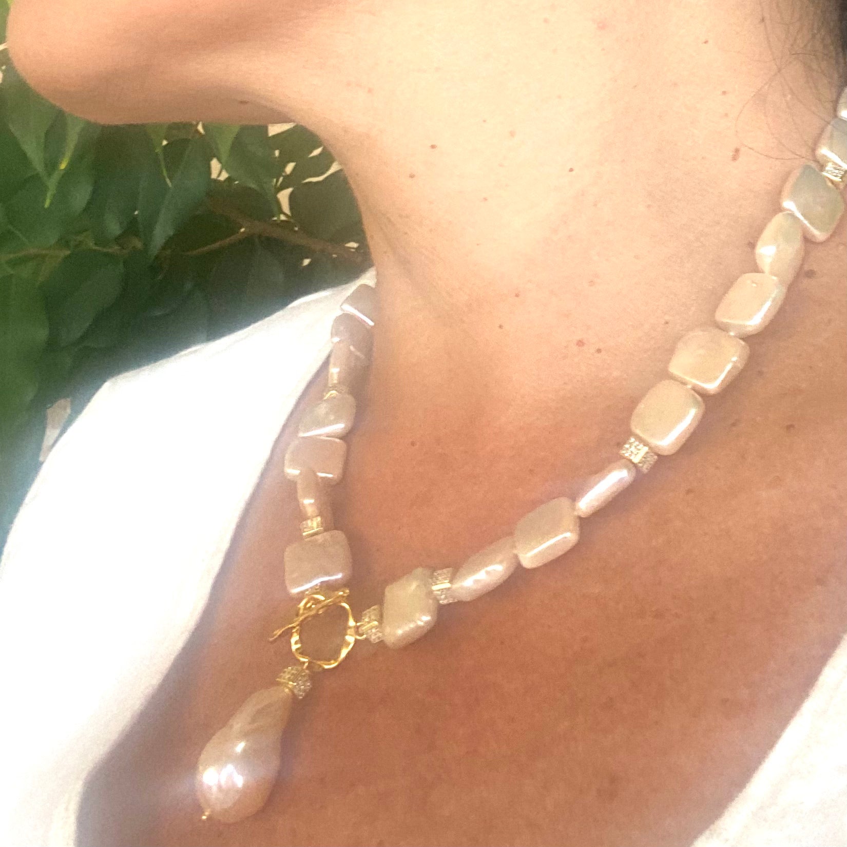 Golden baroque pearl toggle necklace worn by woman — luminous handcrafted statement jewelry with gold details by Loulia Pearl Jewelry