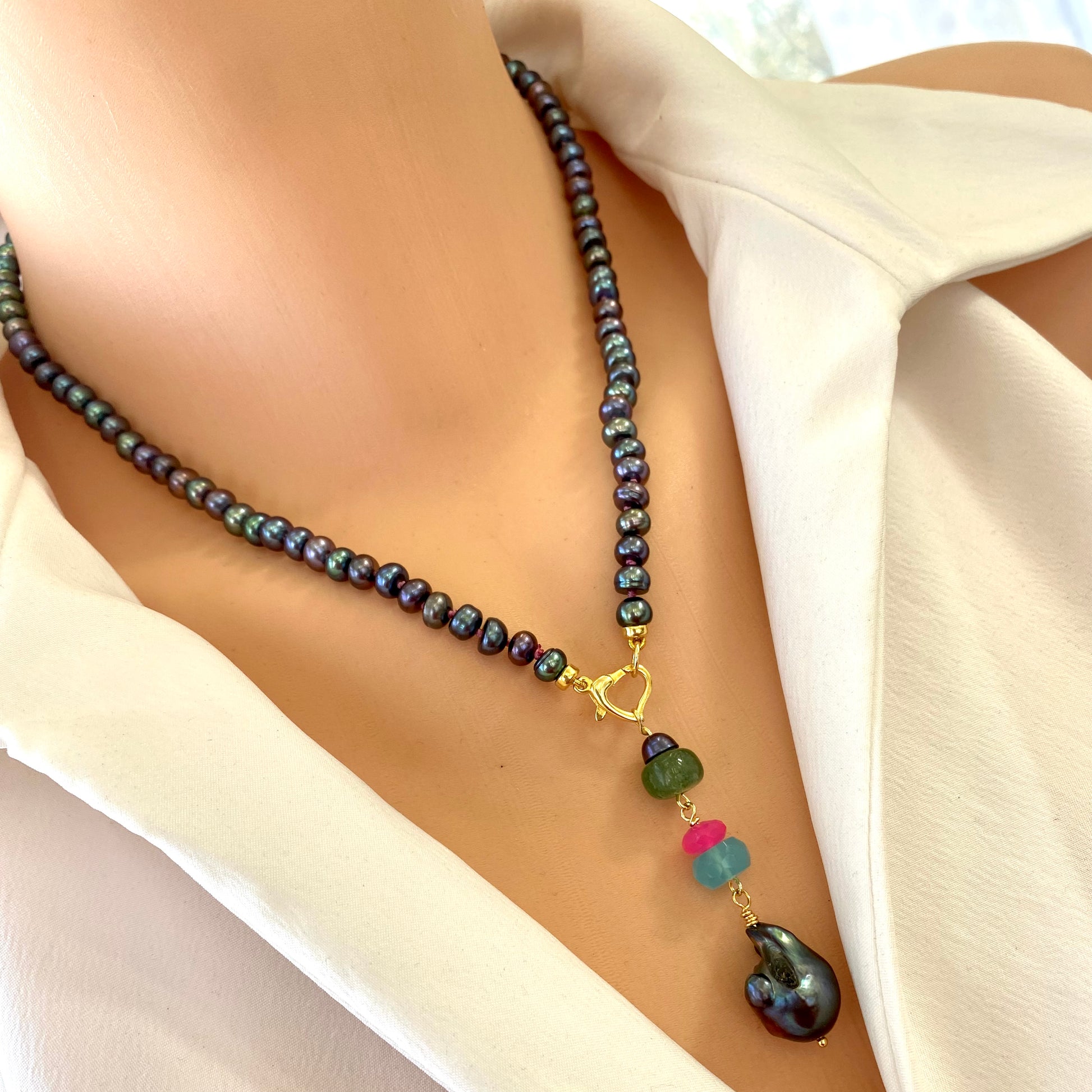 Black pearl necklace with chalcedony and chrysoprase worn on model with heart clasp pendant