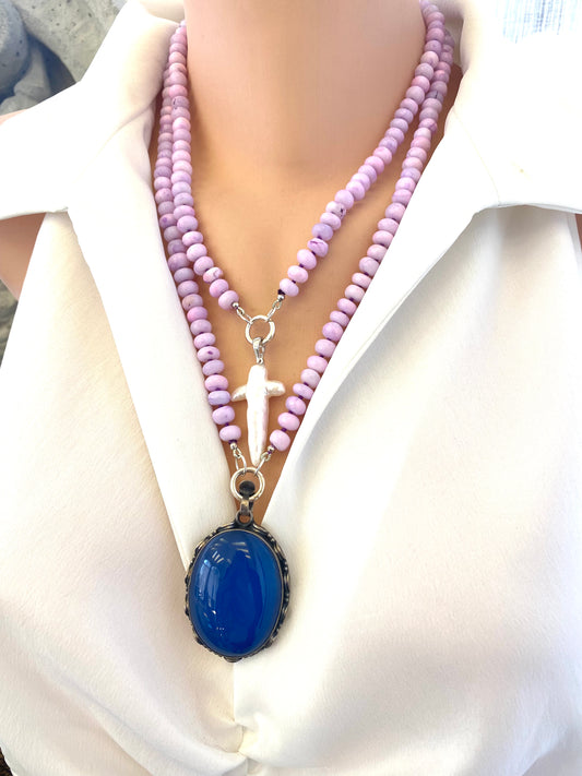 Baroque pearl cross pendant styled on different pearl necklace design, artistic jewelry display.