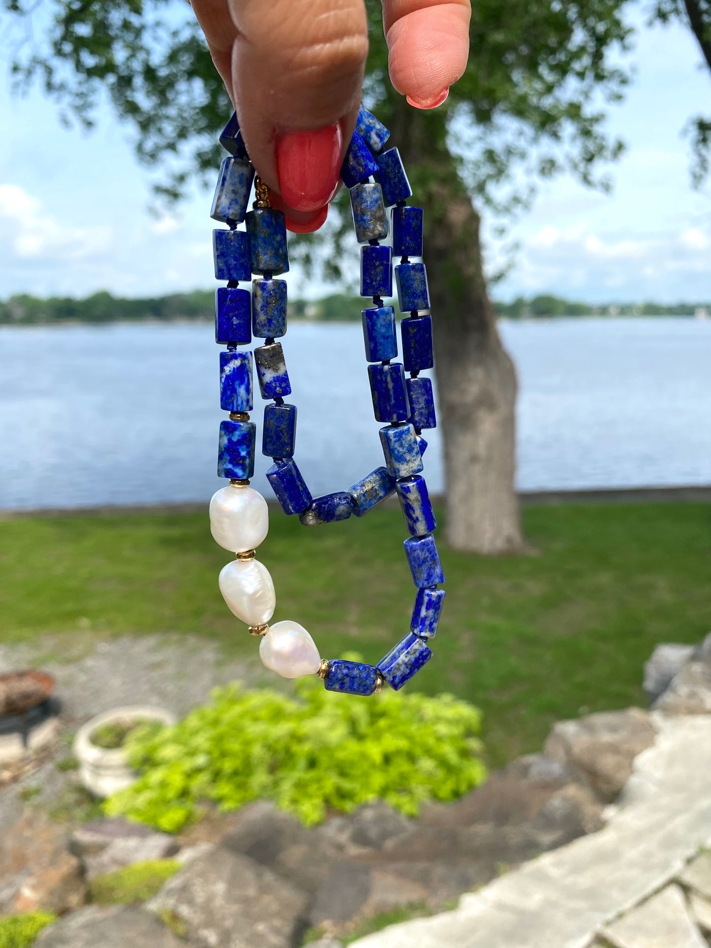 Lapis lazuli pearl necklace displayed outdoors with freshwater pearls and blue gemstones, handmade in Canada