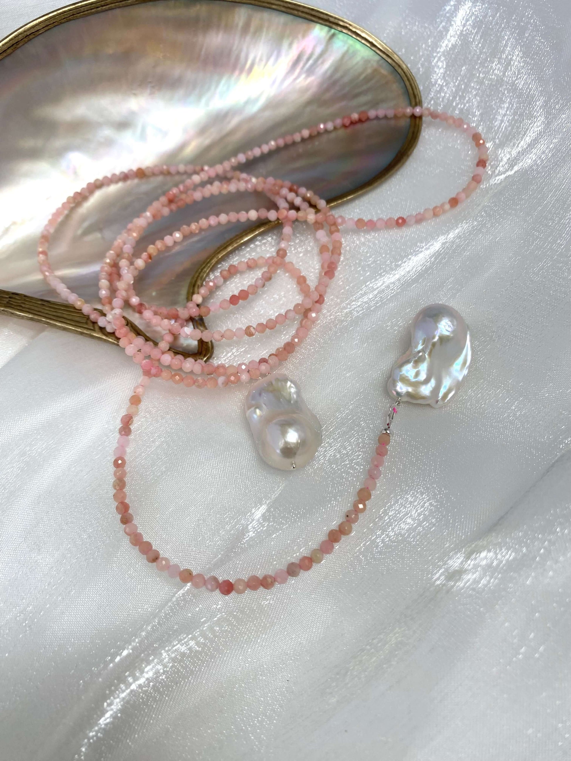 Pink Opal Baroque Pearl Necklace featuring pink opal beads and large baroque pearls against a pearl shell background
