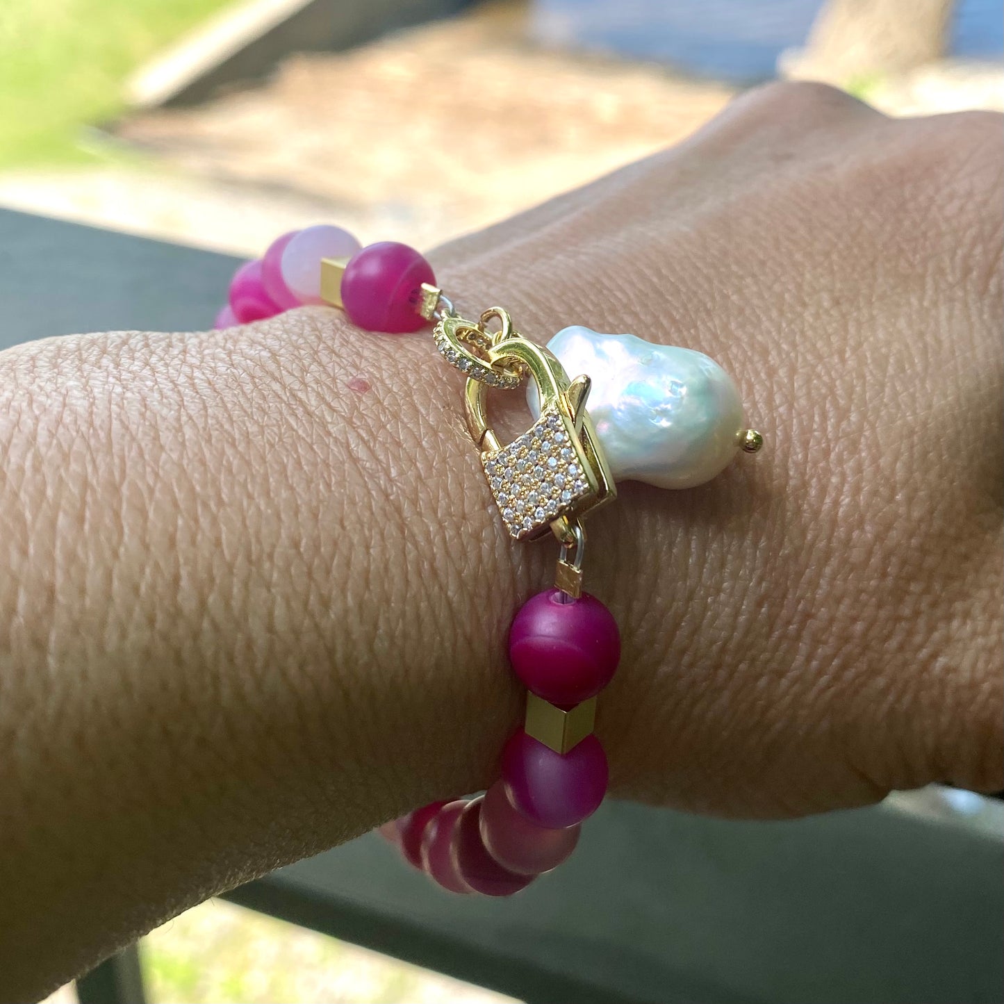 Sardonyx baroque pearl bracelet worn on wrist with hot pink beads and gold plated details