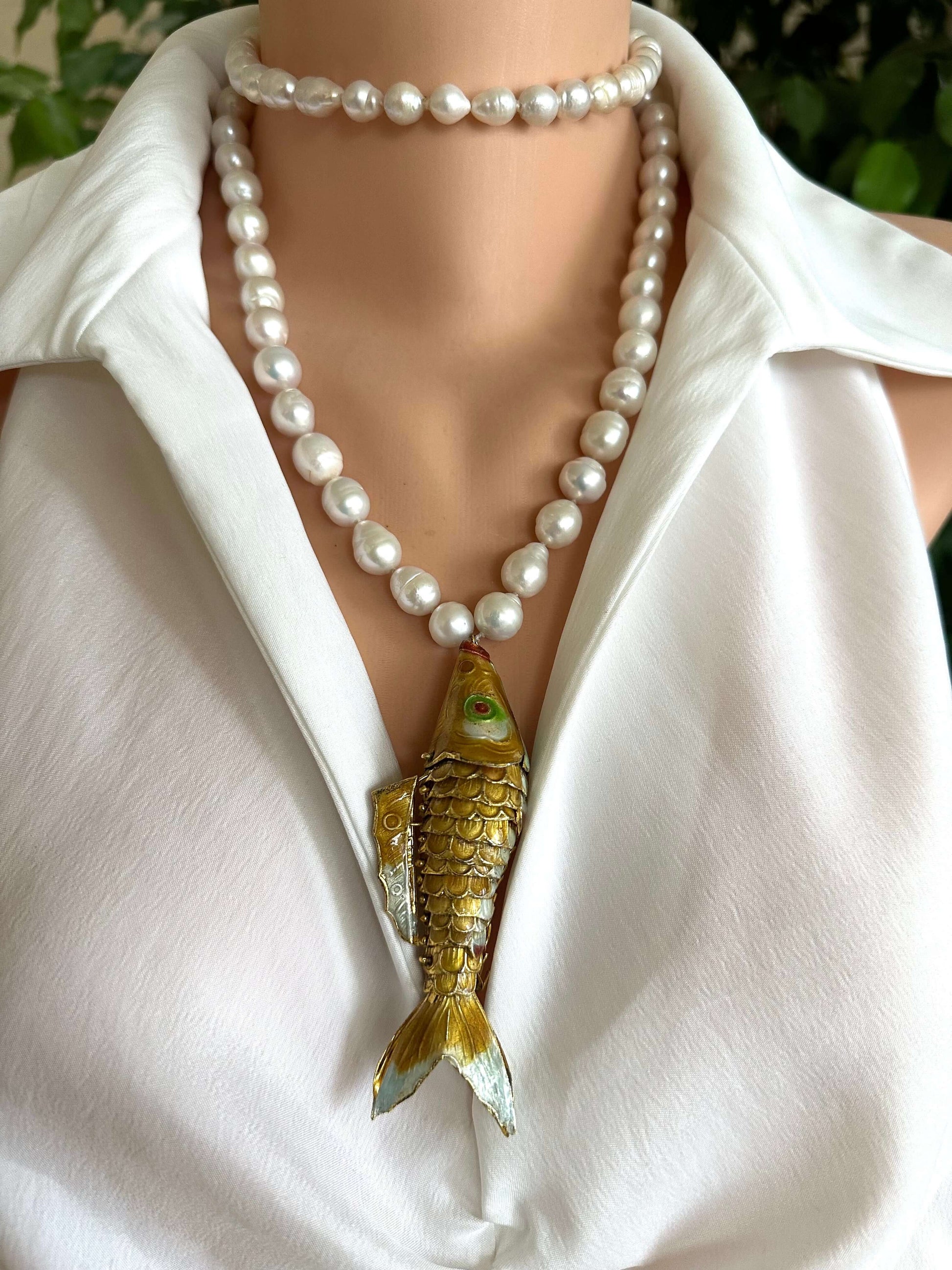Baroque pearl necklace with fish pendant featuring hand knotted white pearls and a gold-tone fish centerpiece.