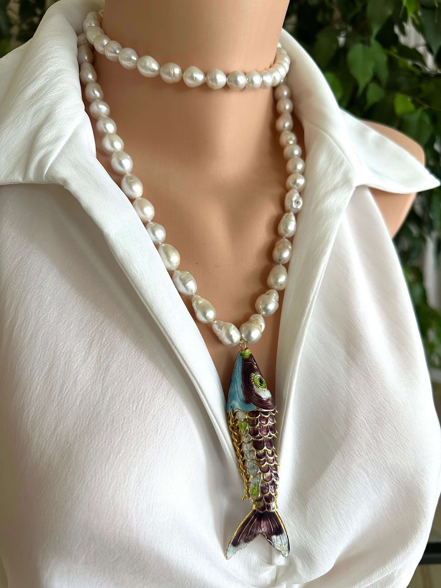 Koi fish pearl necklace with baroque pearls on a mannequin wearing a white shirt.