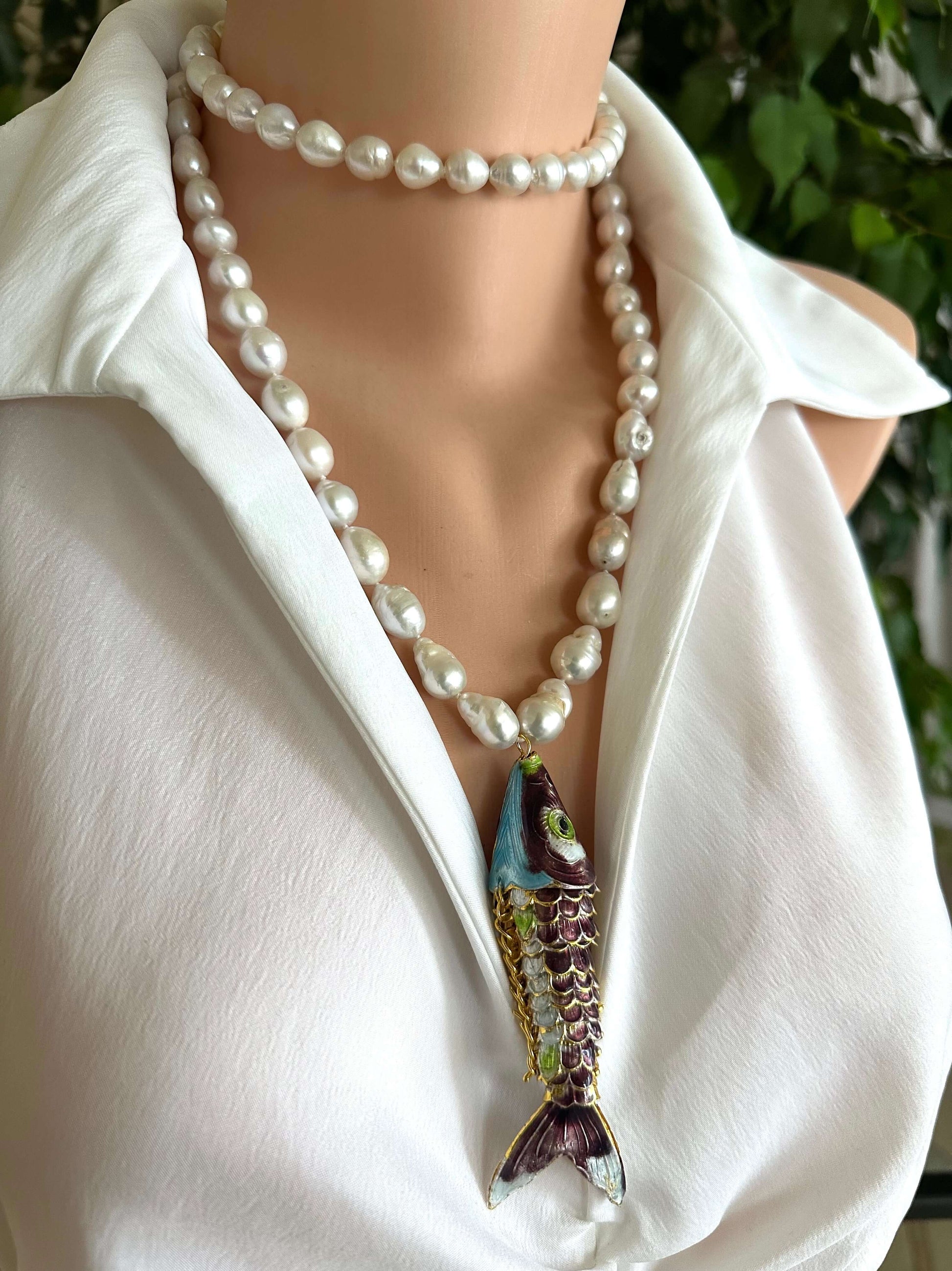 Koi fish pearl necklace with baroque pearls on a mannequin wearing a white shirt.
