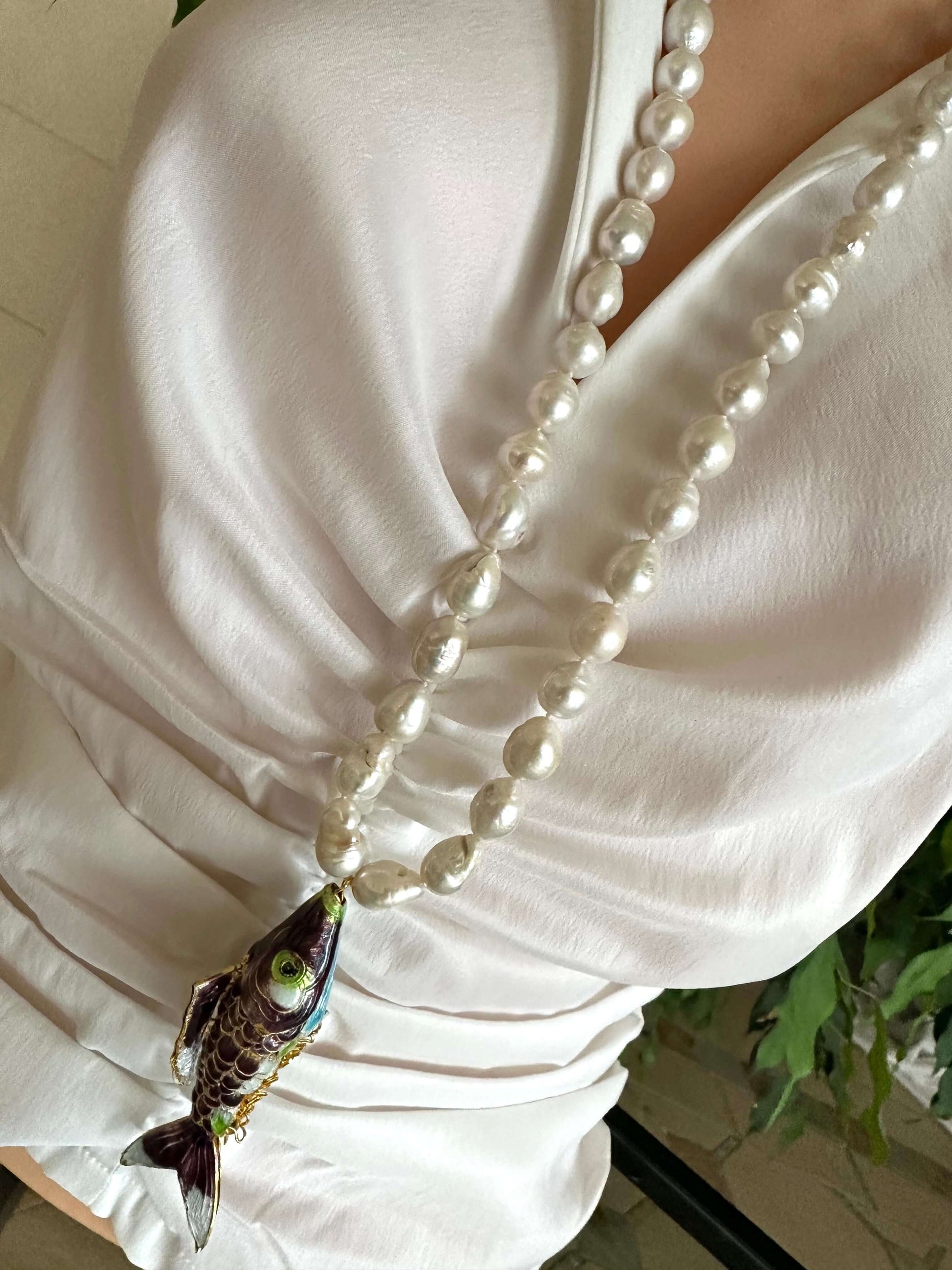 Koi fish pearl necklace featuring a large burgundy cloisonné koi fish pendant and white baroque pearls.