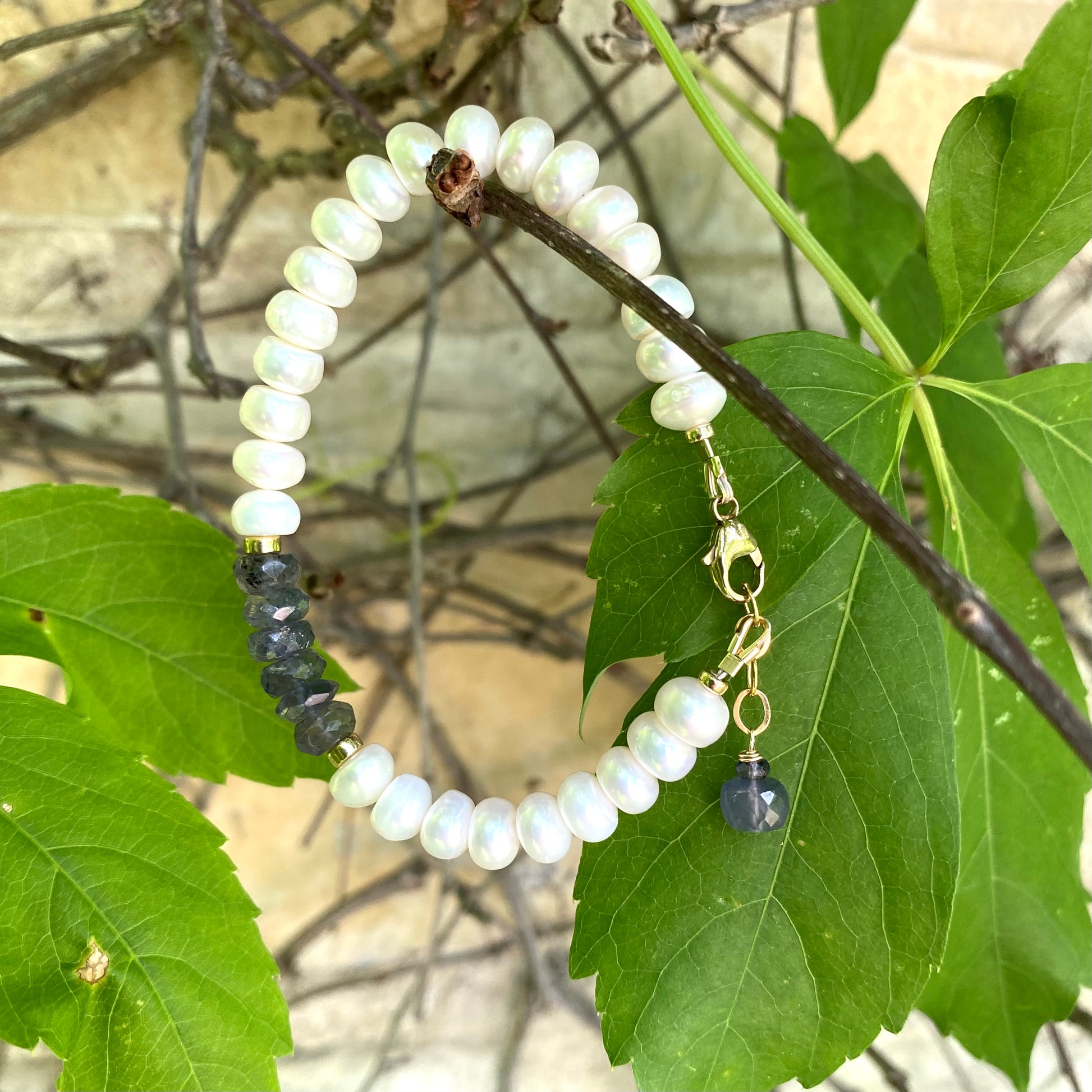 Iolite pearl bracelet featuring white pearls and blue iolite rondelle beads, showcasing elegance and rich gemstone color.