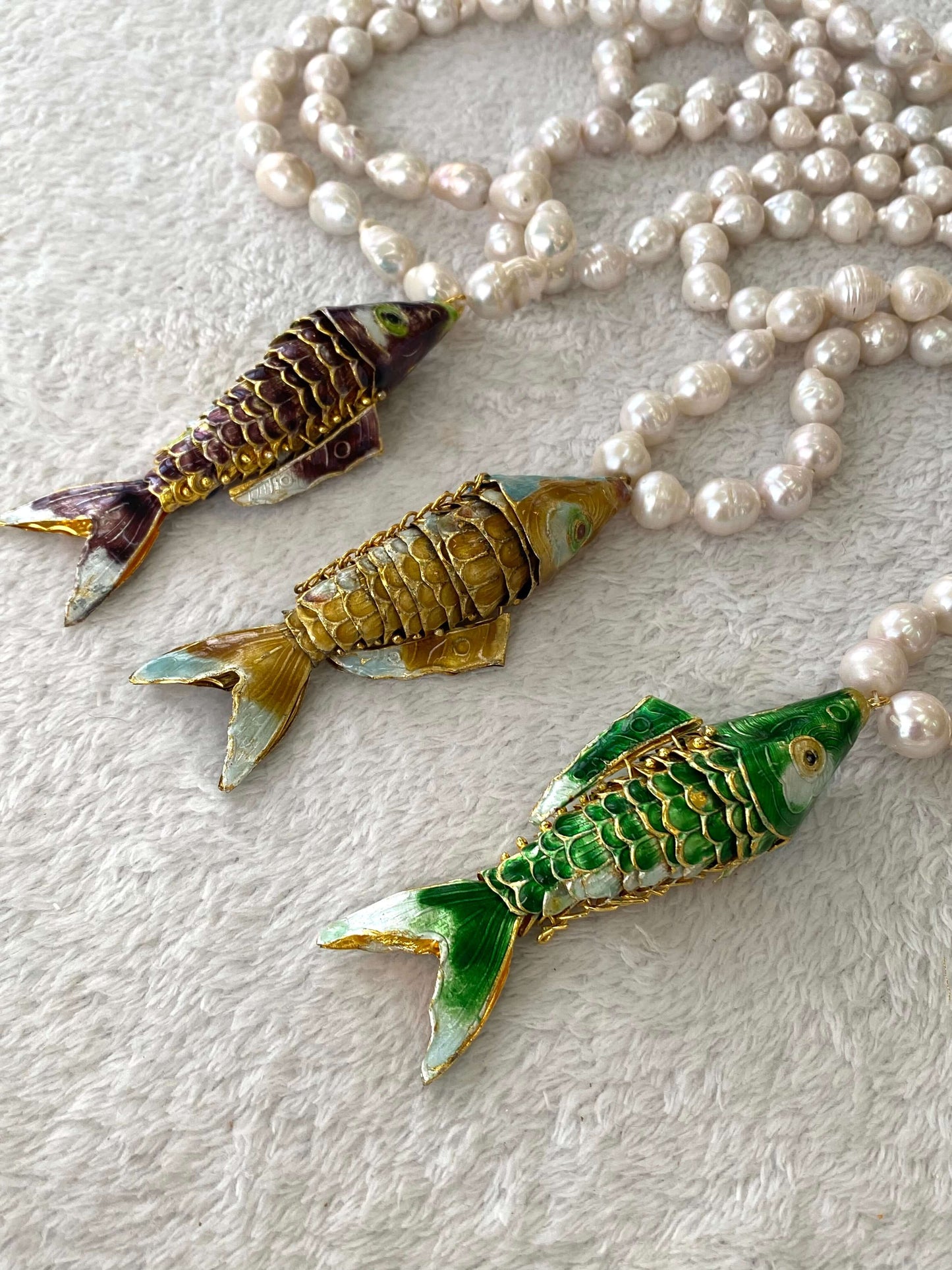 Baroque pearl necklace with fish pendant featuring three colorful fish pendants and lustrous white pearls.