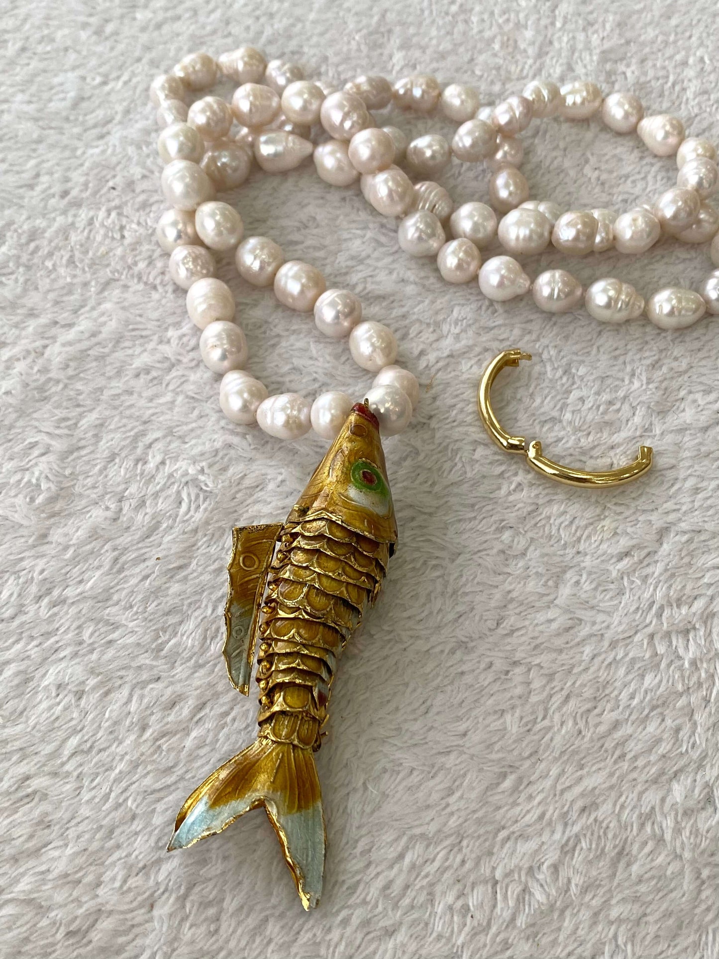 Baroque pearl necklace with fish pendant featuring hand-knotted white pearls and a gold-tone fish charm.