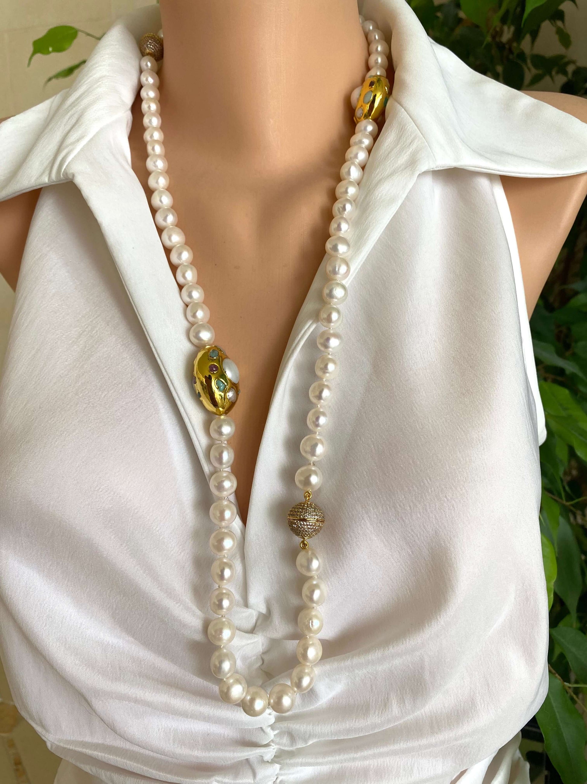 White pearl necklace with gold accent displayed on a mannequin, featuring 9-11mm freshwater pearls and gold-plated accents.