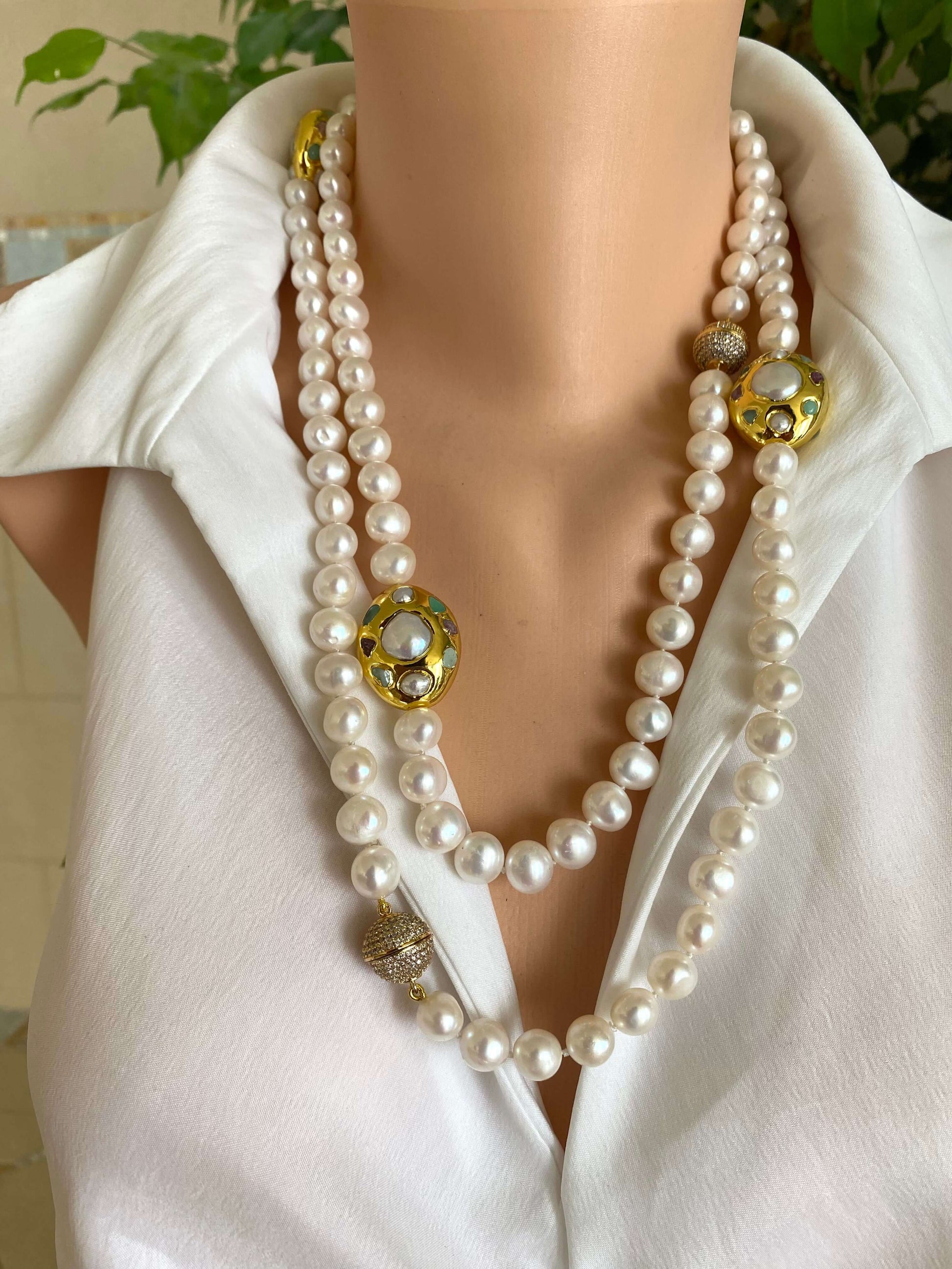White pearl necklace with gold accent displayed on mannequin, showcasing elegant freshwater pearls and gold accents.