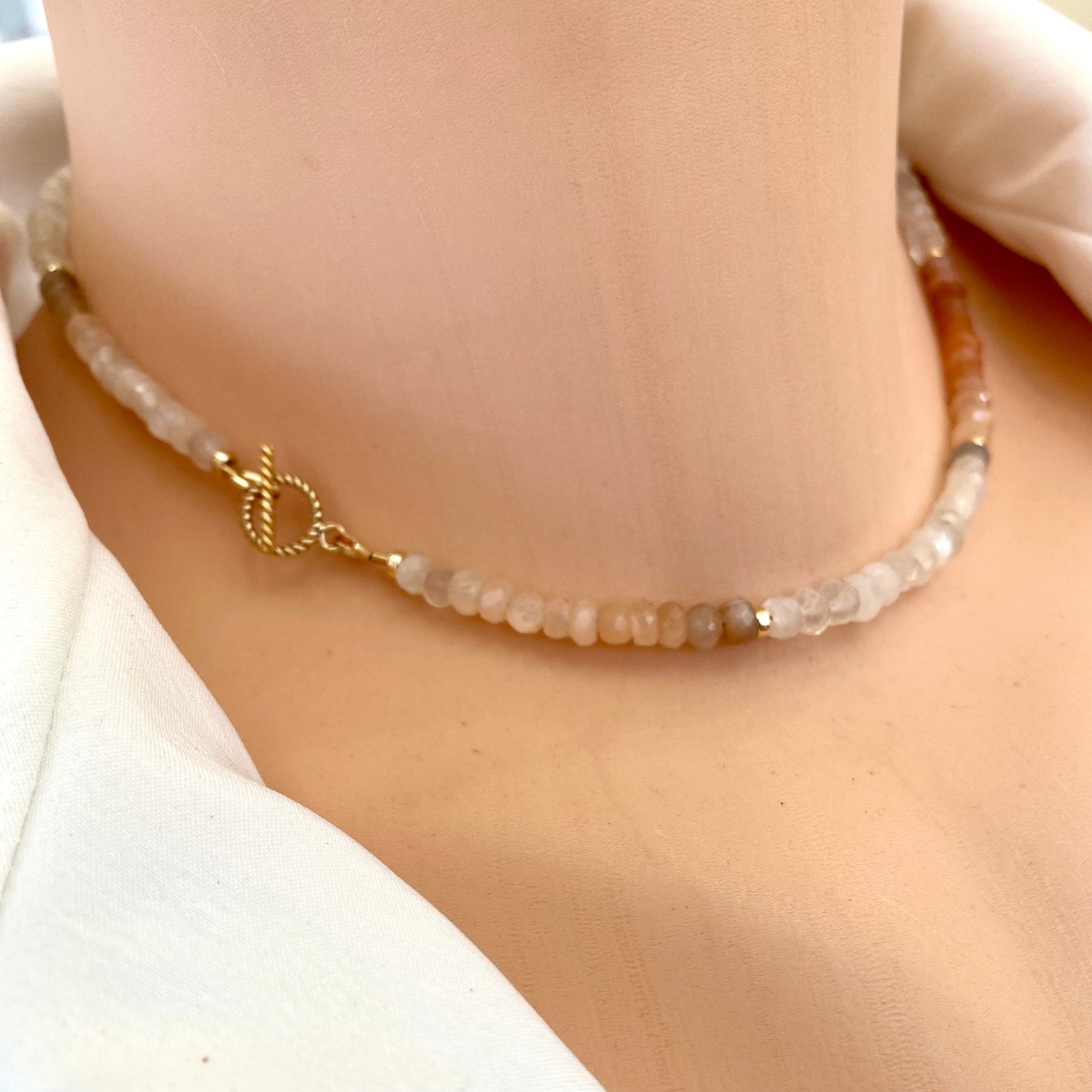 Moonstone choker necklace showcasing delicate multi moonstone beads with a gold clasp, highlighting its subtle beauty.