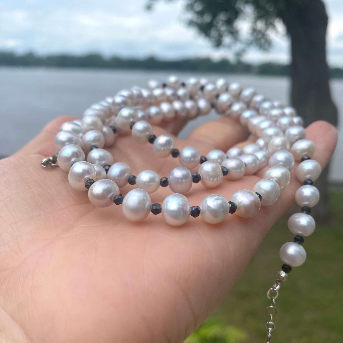 Light grey freshwater pearl necklace featuring silver and charcoal spinel beads in elegant design.