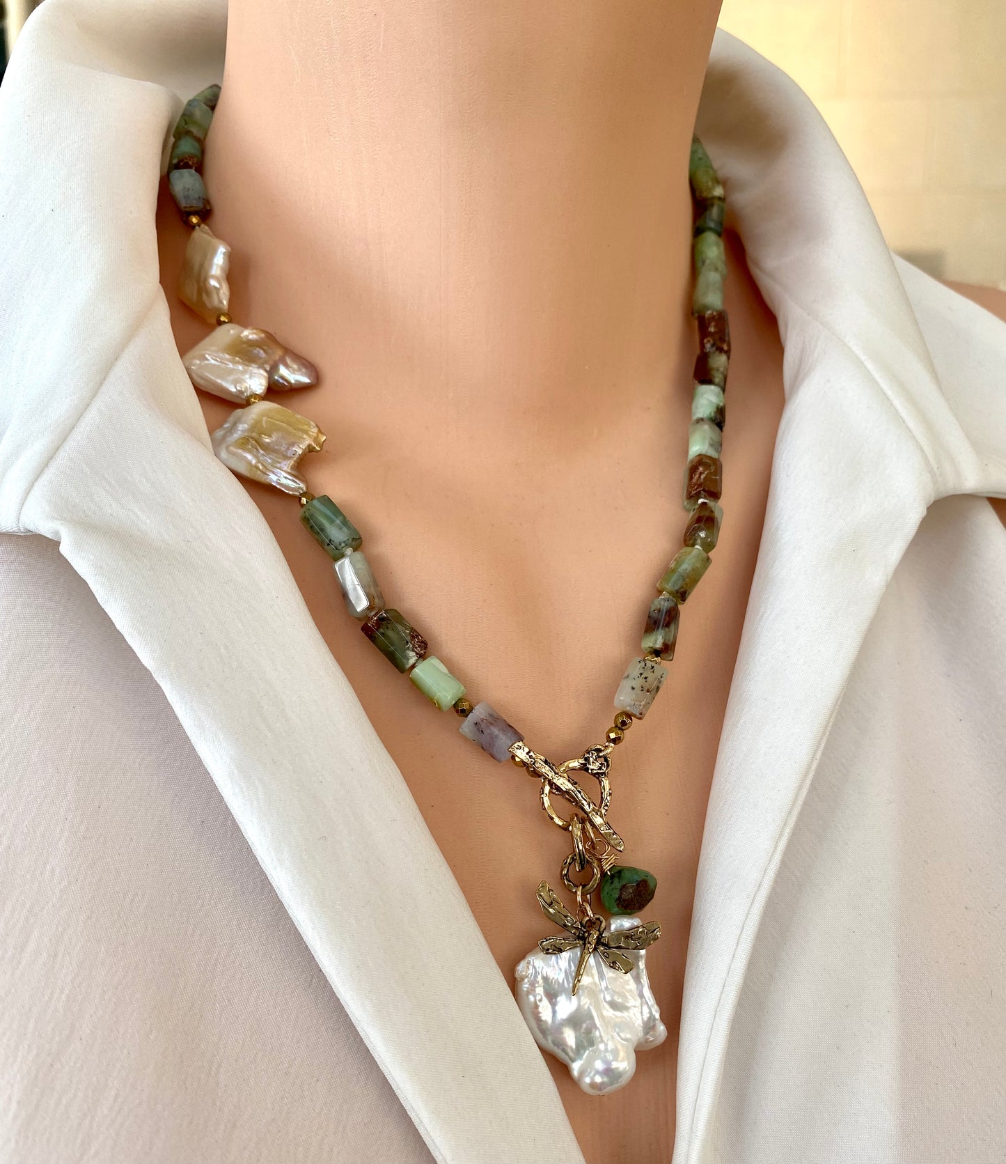 Chrysoprase necklace with dragonfly charm and baroque pearls displayed on a mannequin.