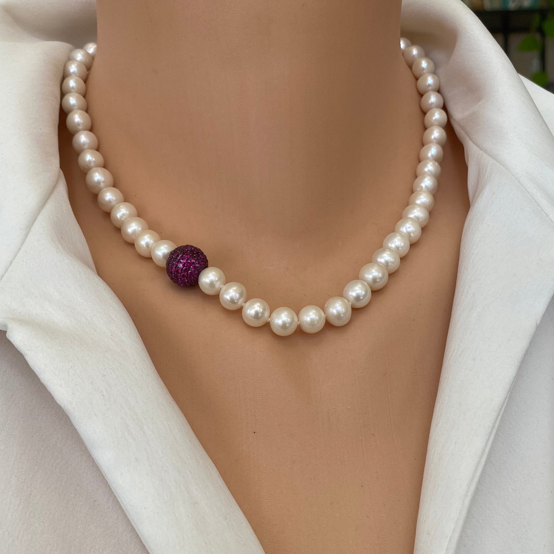 Pearl necklace with ruby red CZ bead, handmade in Canada, featuring lustrous freshwater pearls.