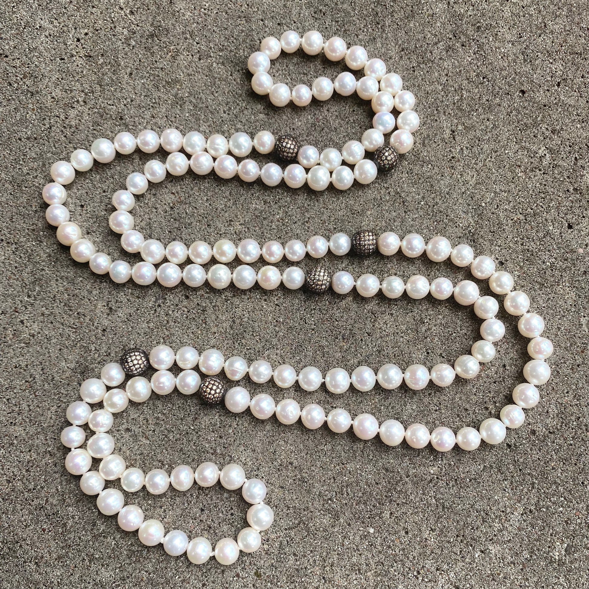 Elegant 55 inch freshwater pearl necklace with CZ pave silver beads on dark grey background, handmade in Canada.