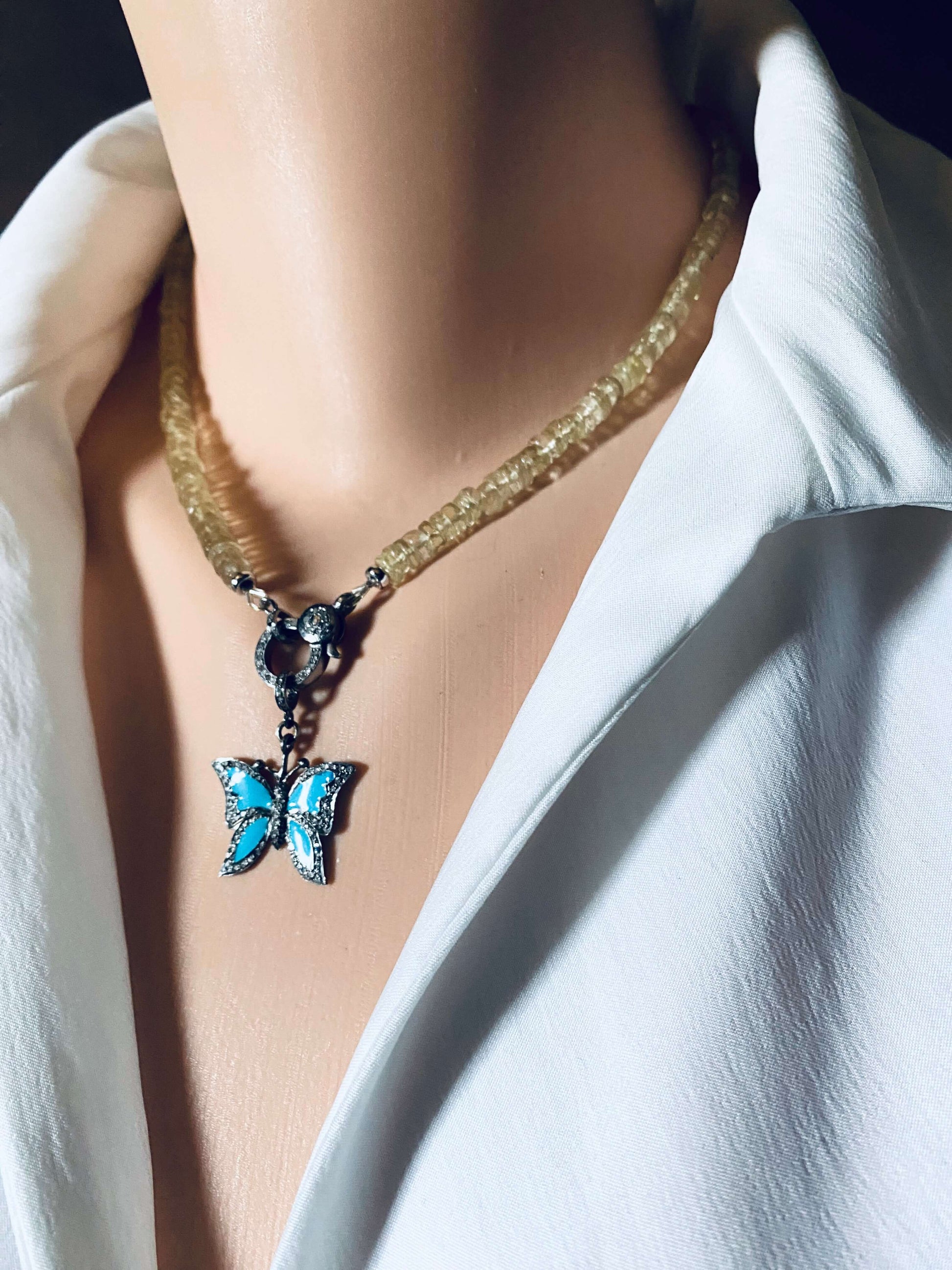 Lemon quartz beaded necklace with oxidized silver pavé clasp and butterfly pendant on model.