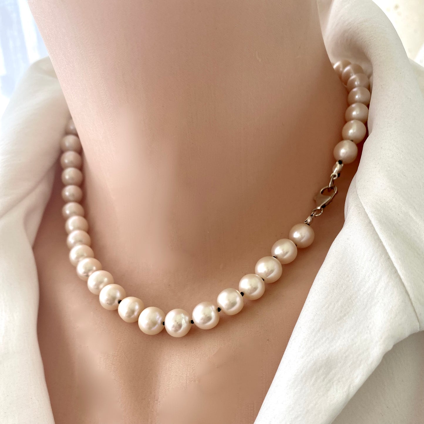 Off white pearl choker necklace on mannequin, close-up detail