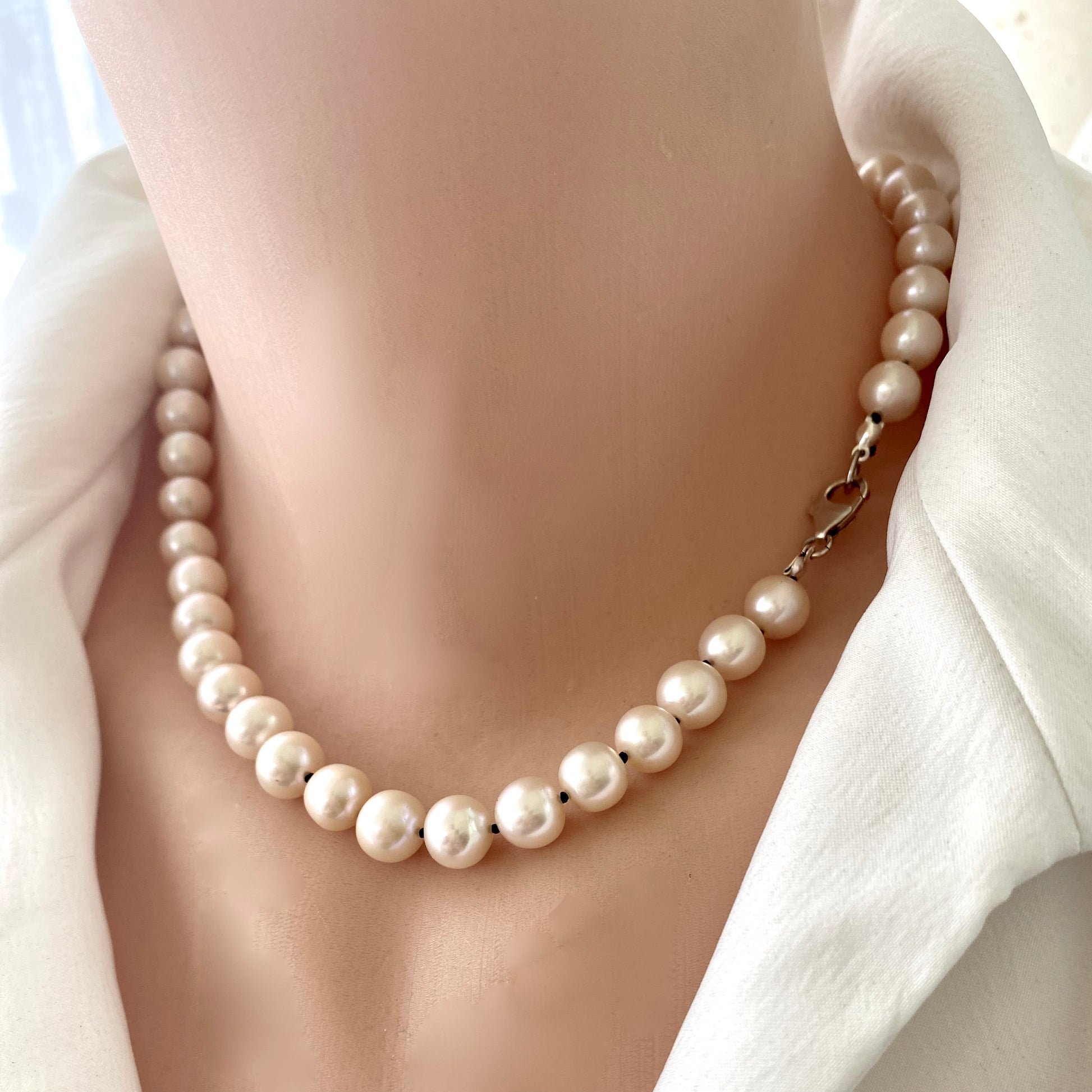 Off white pearl choker necklace on mannequin, close-up detail