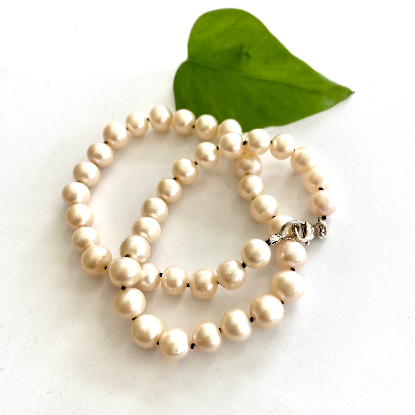 Off white pearl choker necklace close-up on white fabric