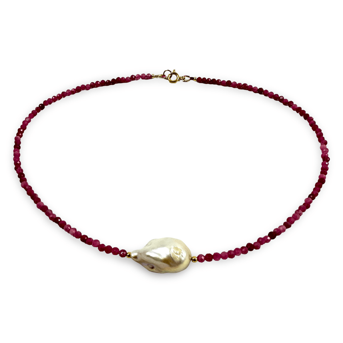 A beaded necklace featuring a strand of faceted dark red beads and a large, irregular white baroque pearl pendant, accented with small gold spacers and a gold clasp, shown on a plain white background.