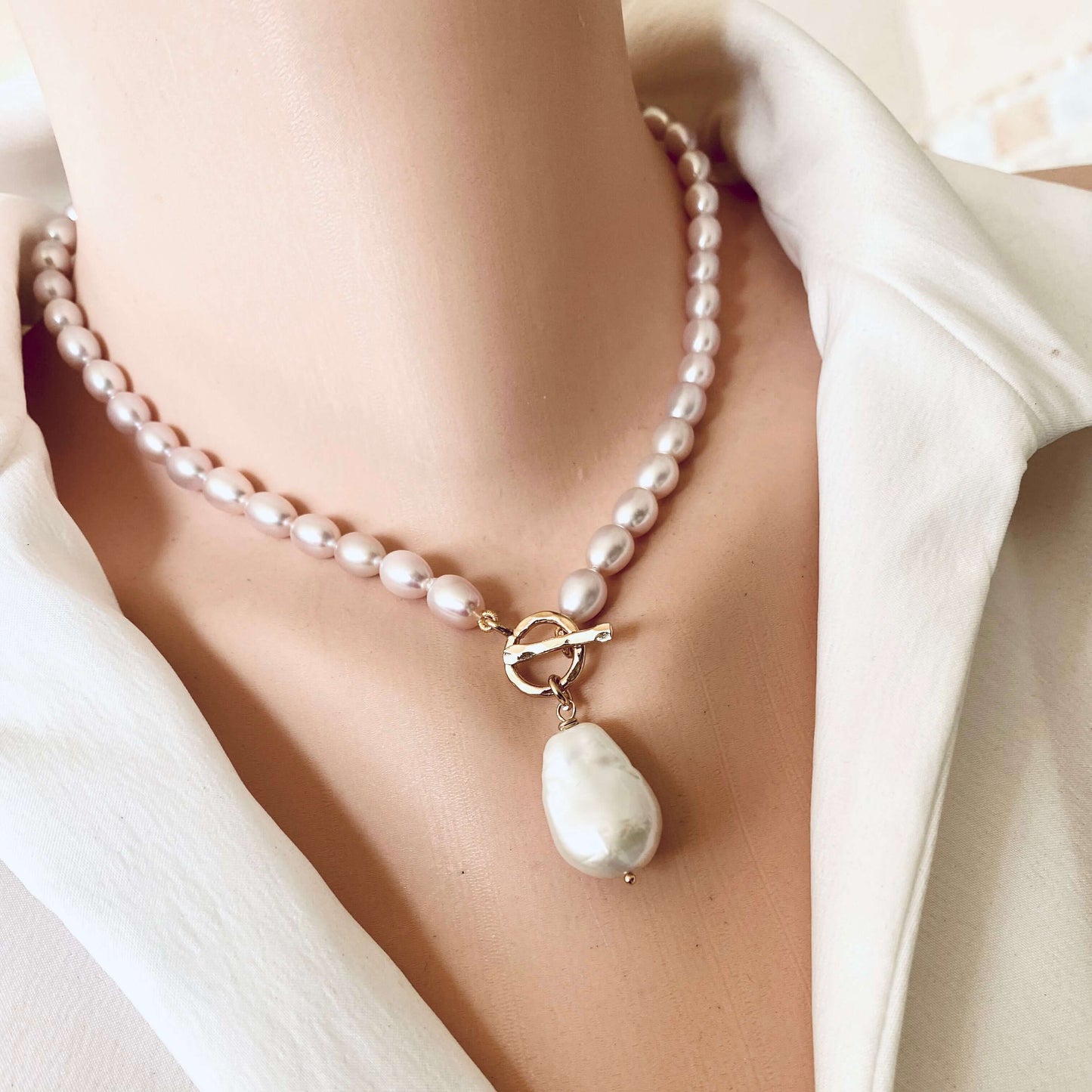 Pink pearl toggle necklace with baroque pearl styled close to neckline with feminine pink tones