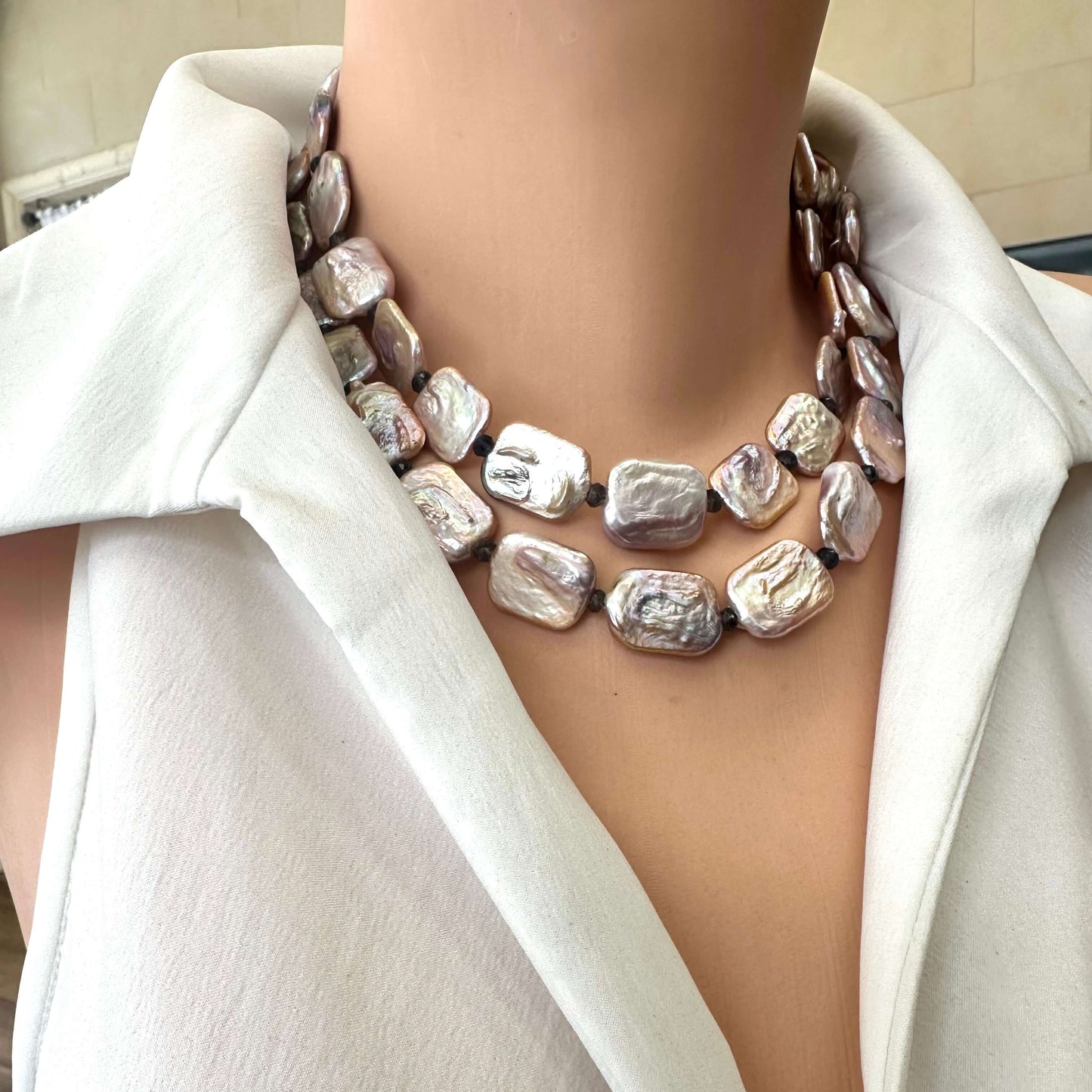 Detailed side close-up of two-strand Statement Pearl Necklace featuring pink pearls and iolite beads on mannequin neck.